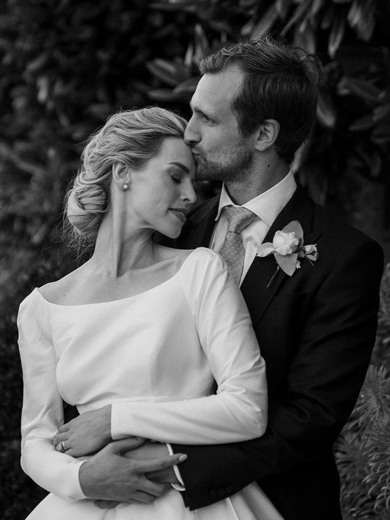 Bride and groom embracing during a romantic wedding portrait.