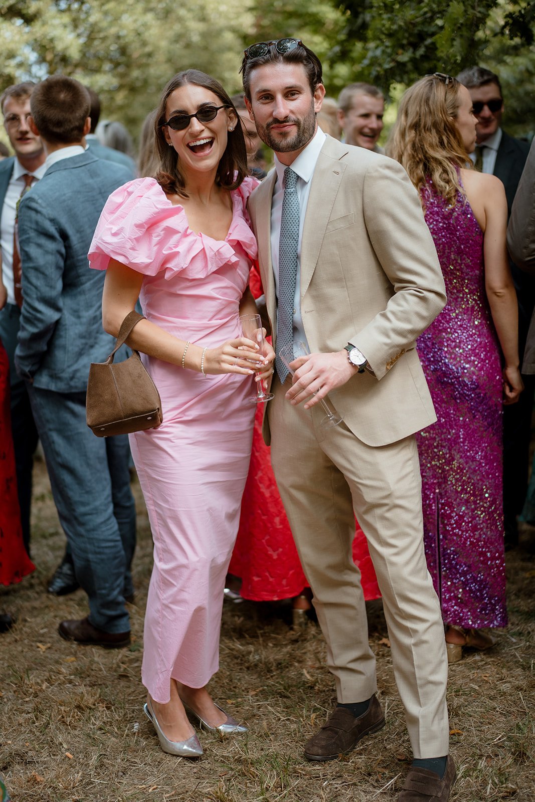 Guests smiling and reacting during an outdoor wedding ceremony in natural light
