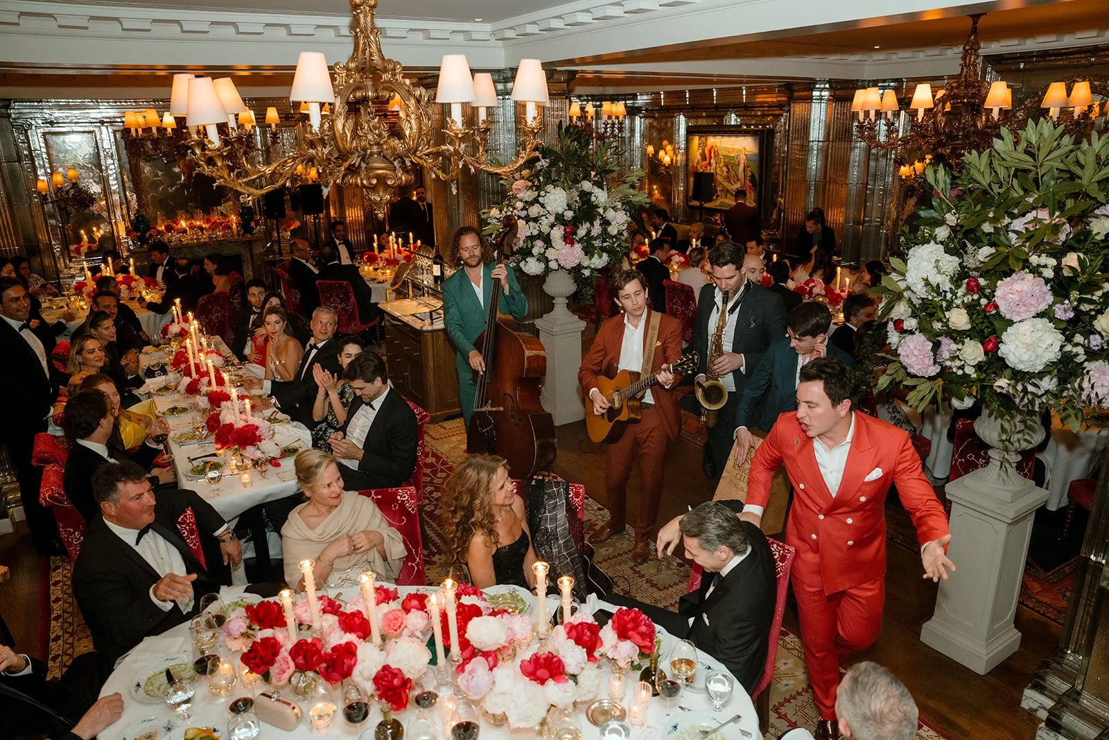 Guests celebrating and dancing between tables during a wedding reception dinner.