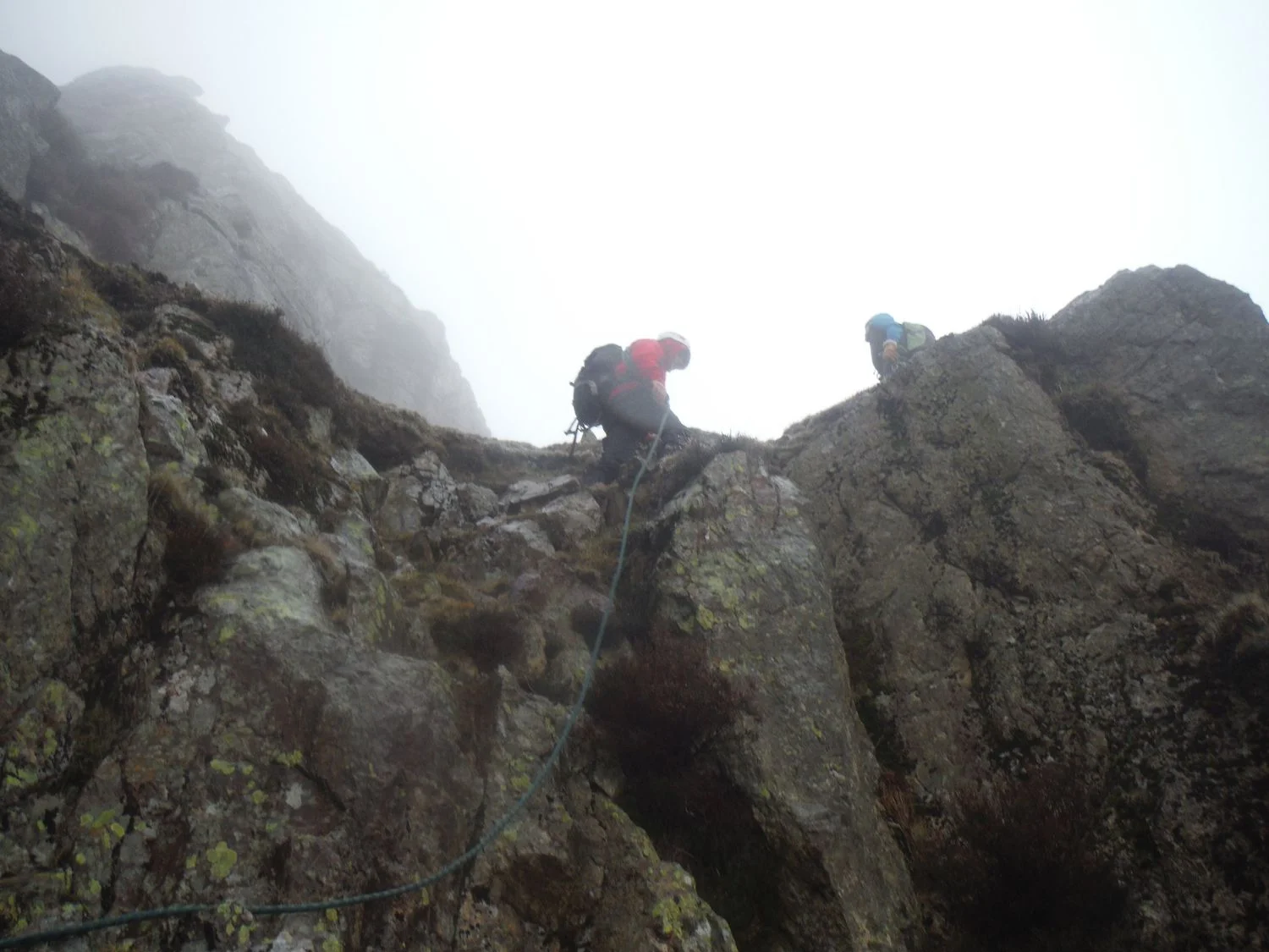 a mountaineer reaching the top of a scramble - Chris Ensoll Mountain Guide