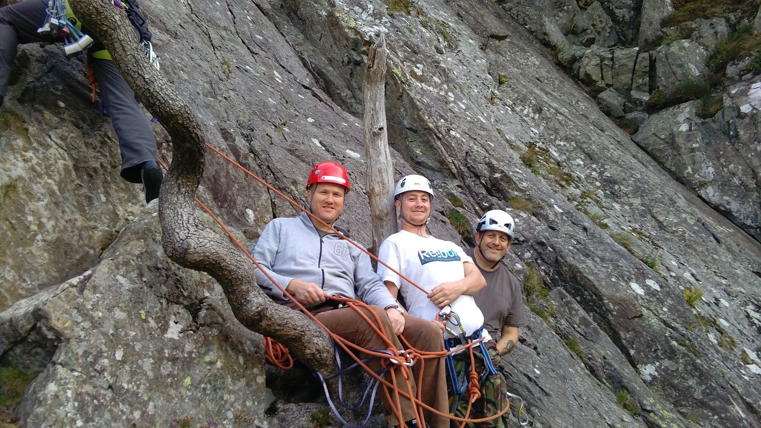  A group of clients belaying at the bottom of a single pitch rock route in the Lake District - Chris Ensoll Mountain Guide 