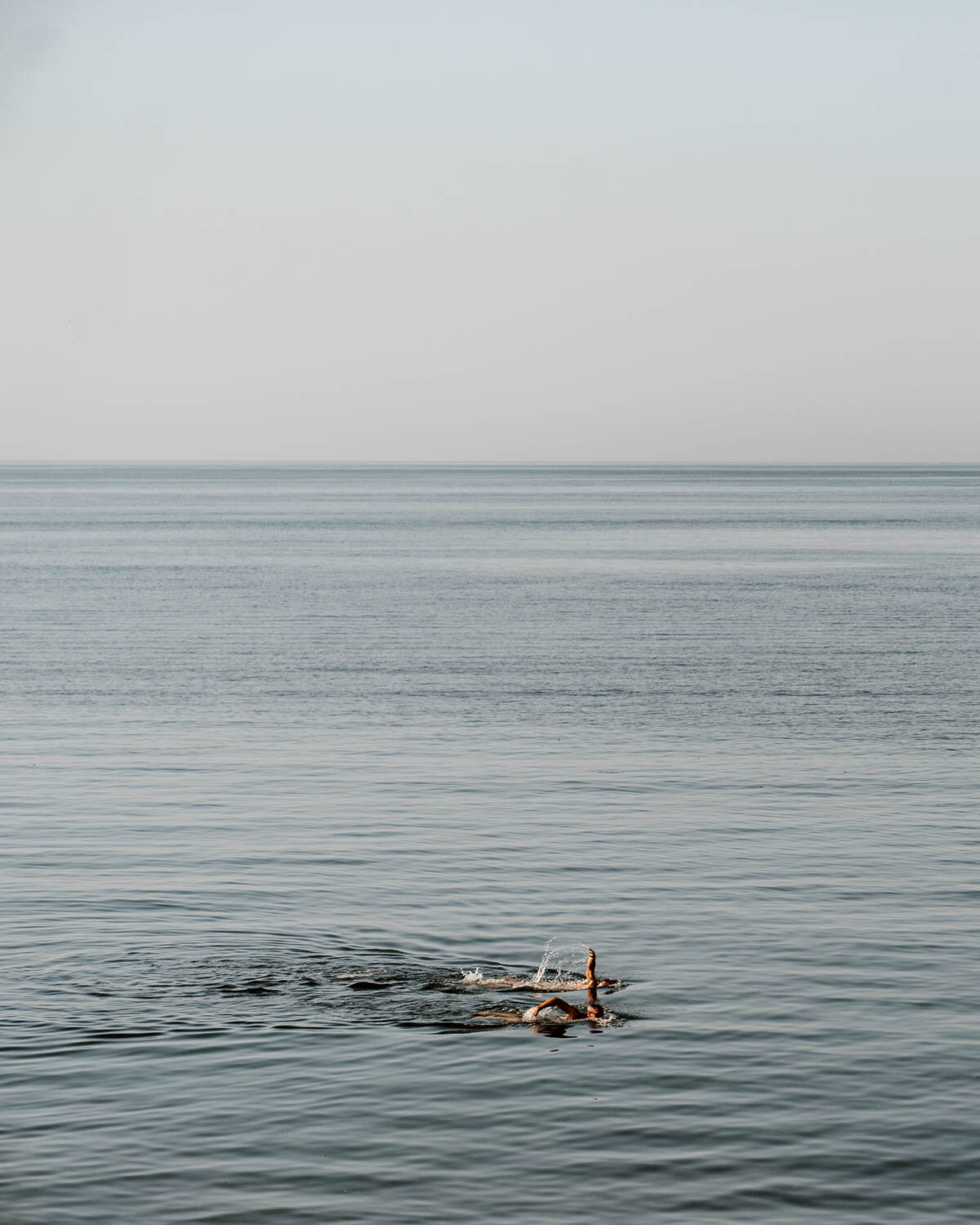 Men swimming at sunset in Trapani