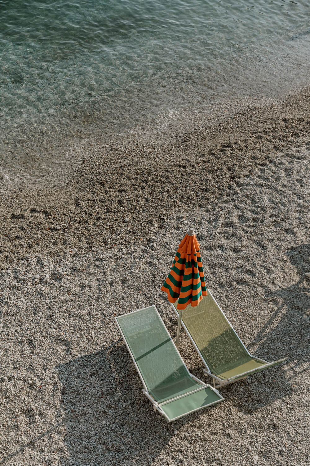 An orange and green parasol on Monterosso beach