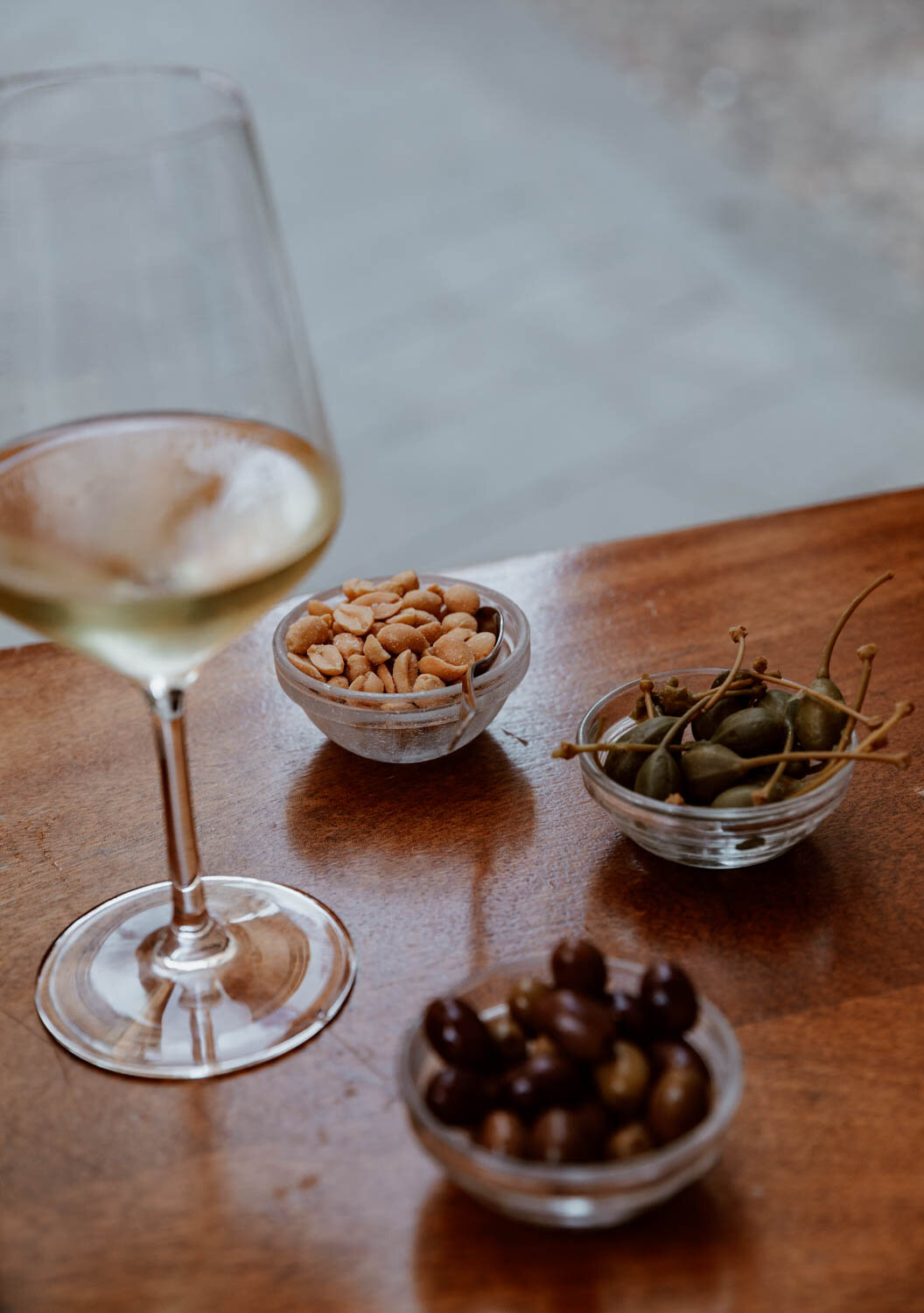 Glass of Cinque Terre wine with olives and capers