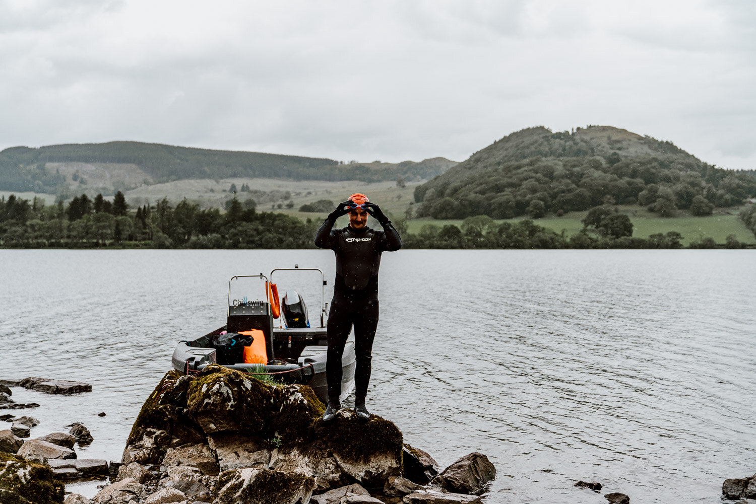 preparing to wild swim with wetsuit, cap and goggles