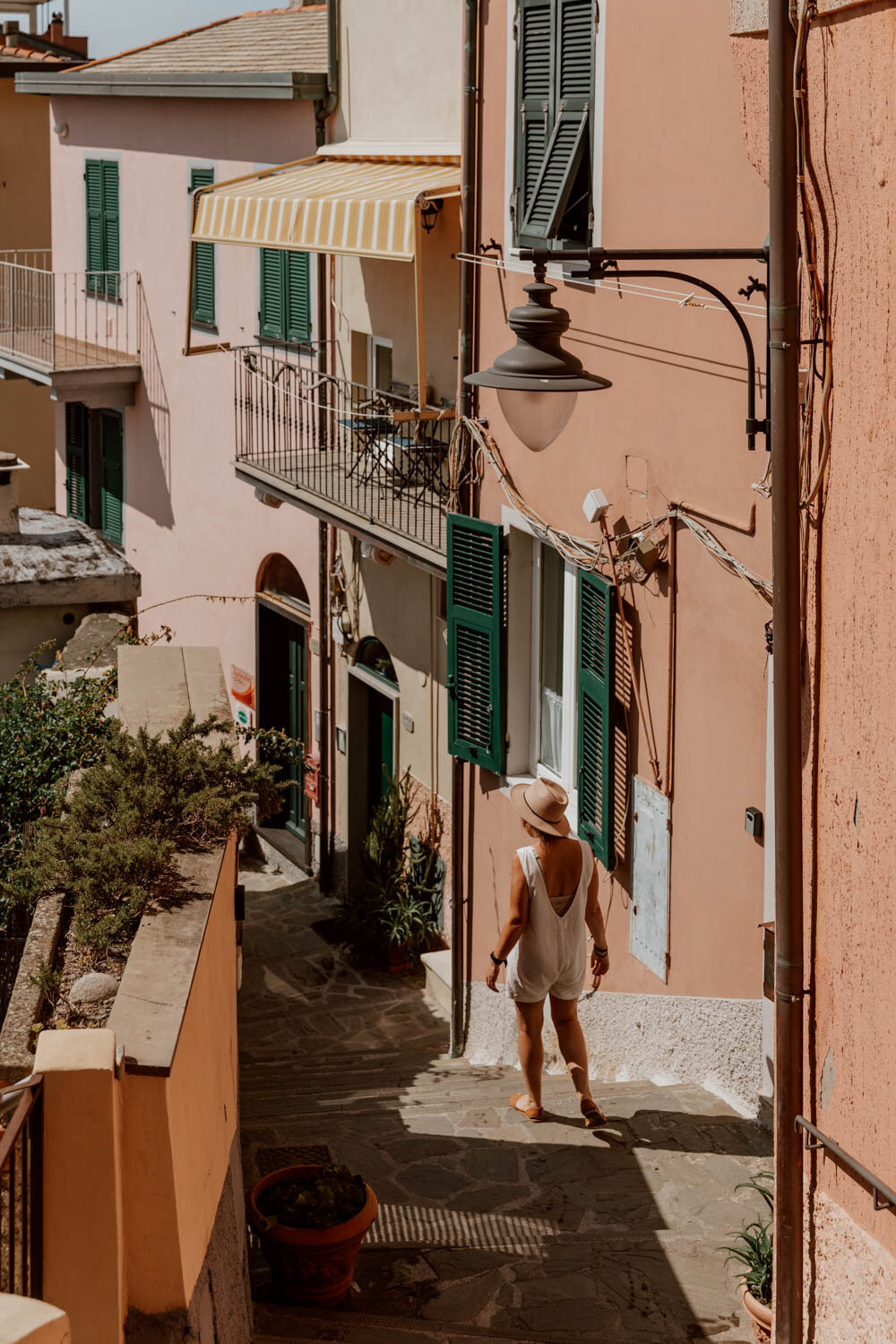 girl walking along narrow street with pink houses