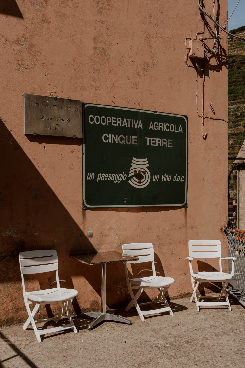 sign for cooperativa agricola cinque terre and chairs in the sun