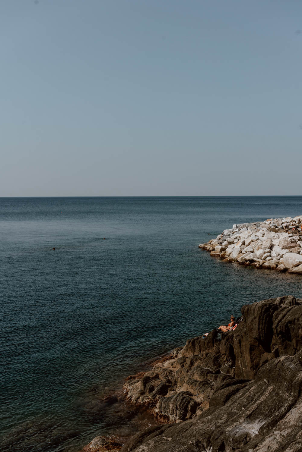 Girl sunbathing on rocks in Riomaggiore