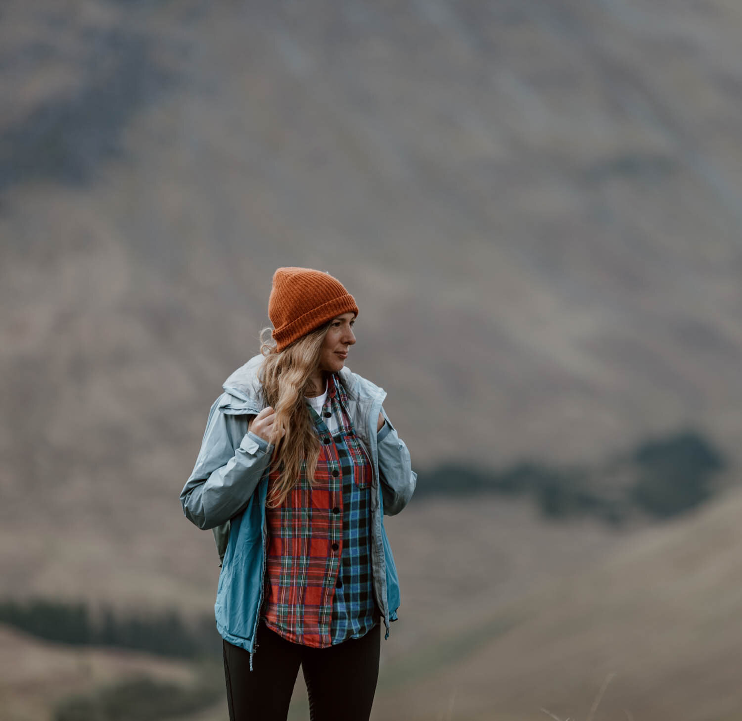 woman stands in hiking clothes in Scottish highlands
