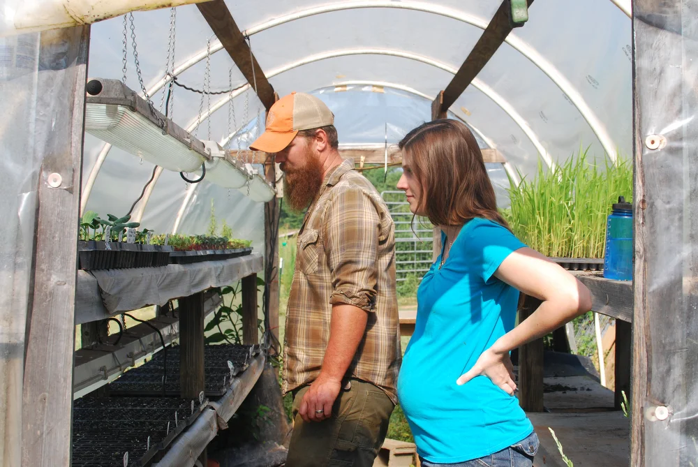 Nathan and Simone Brett inspecting pumpkin seedlings. Photo by me.