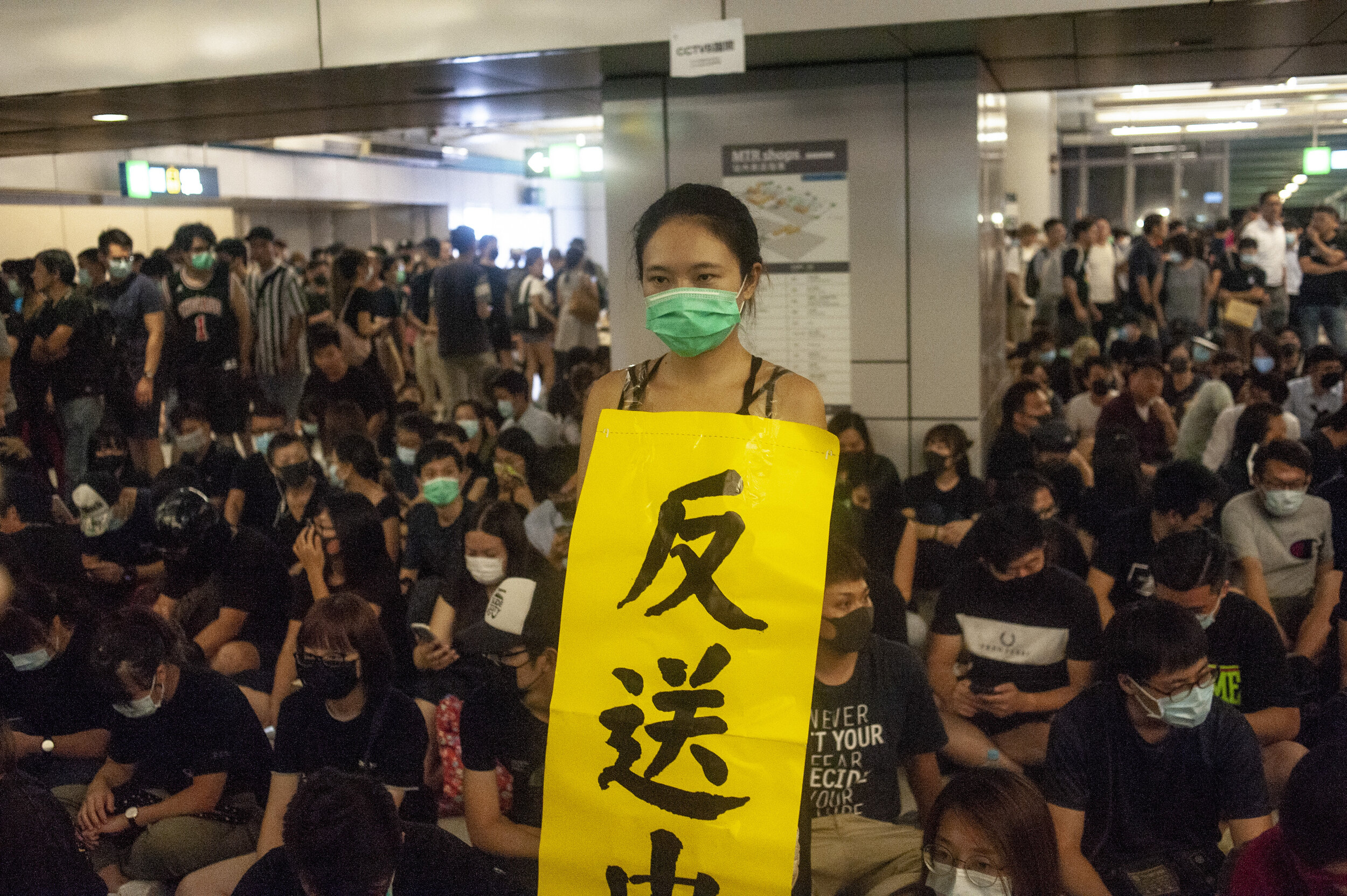  A pro-democracy protester holds a sign while attending a sit-in with other protesters at Yeung Long Station on August 21, 2019. The sit-in was organized to coincide with the one week anniversary of the beatings of protesters at the hands of masked m