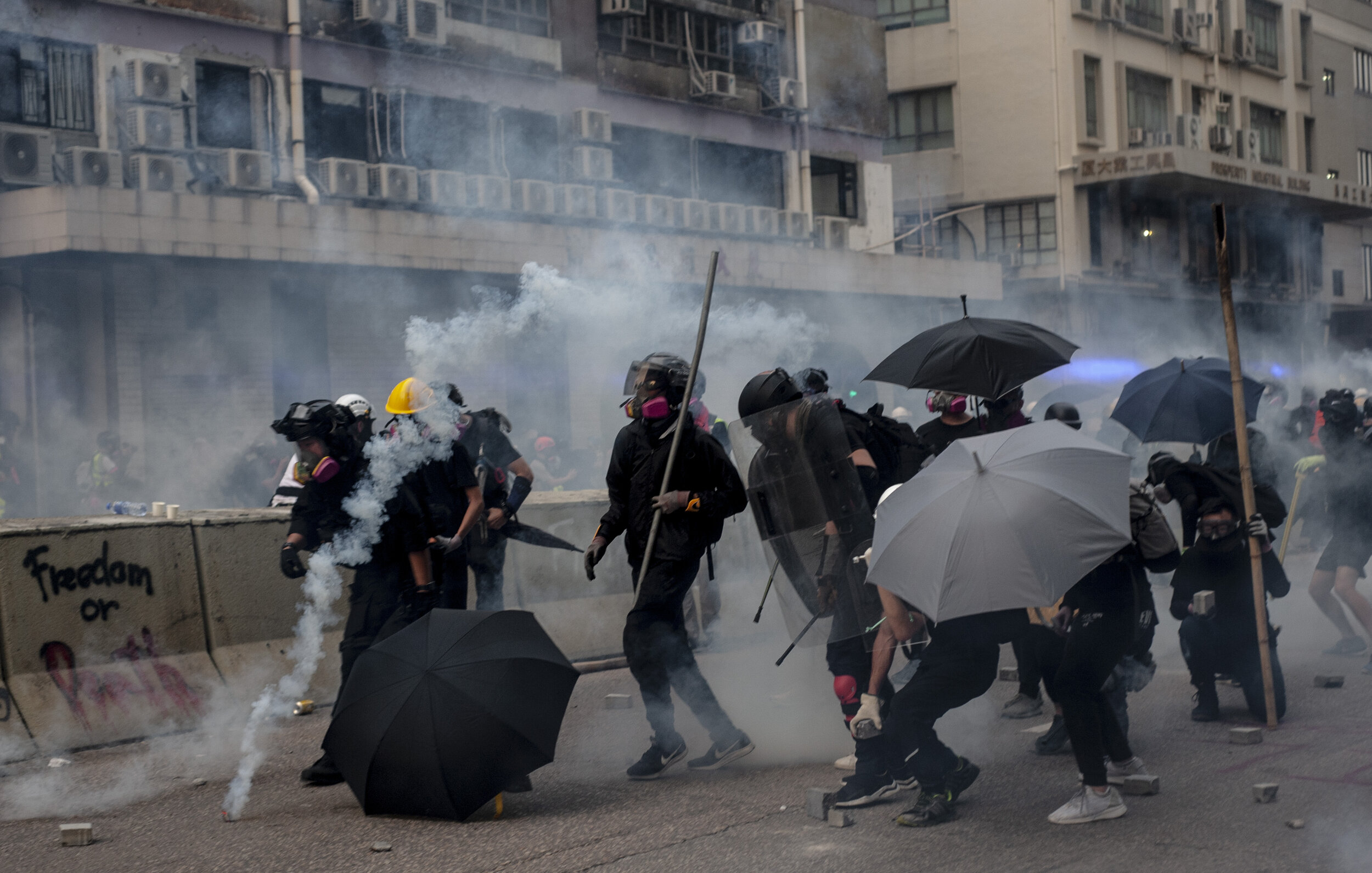  Pro-democracy protesters try to push forward towards police under a hail of tear gas canisters, rubber bullets, and pepper ball rounds during heavy clashes with police in Kwun Tong on August 24, 2019.  