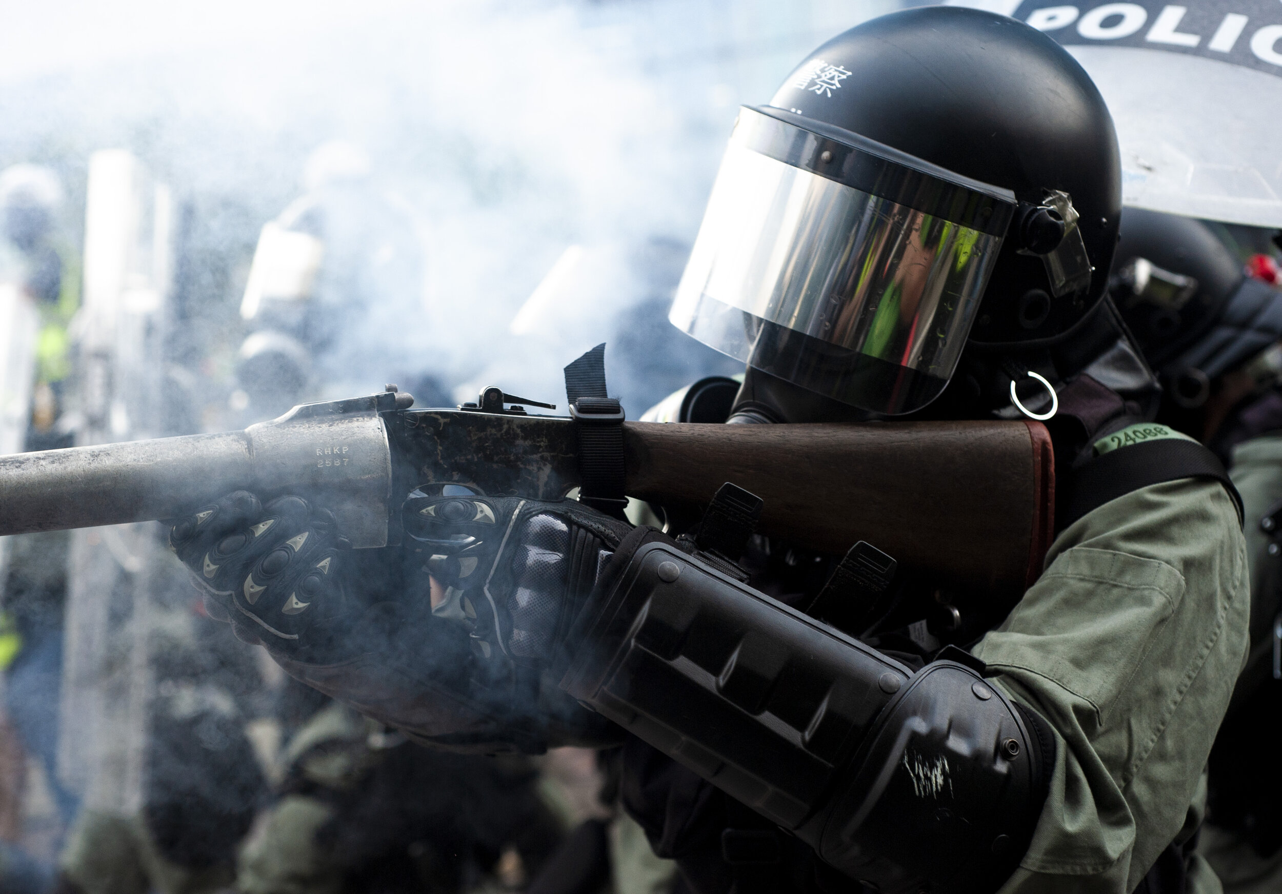  A police officer fires a tear gas canister at pro-democracy protesters during heavy clashes in Kwun Tong on August 24, 2019.  