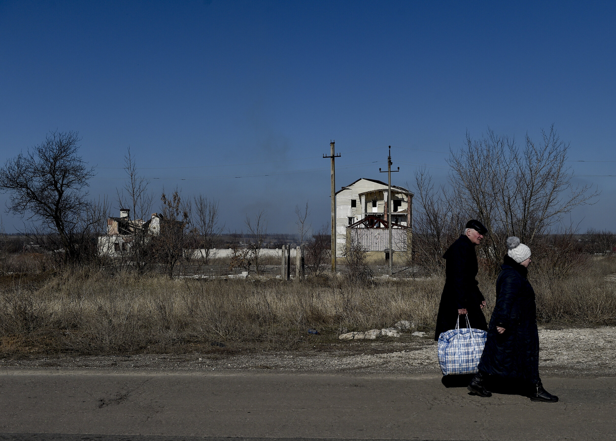  An elderly couple walks past a destroyed home on the outskirts of Pisky on March 20, 2019. Pisky, a small town on the fringes of Avdiivka and the Donetsk Airport, remains uninhabitable after 5 years, most of the buildings have been destroyed beyond 