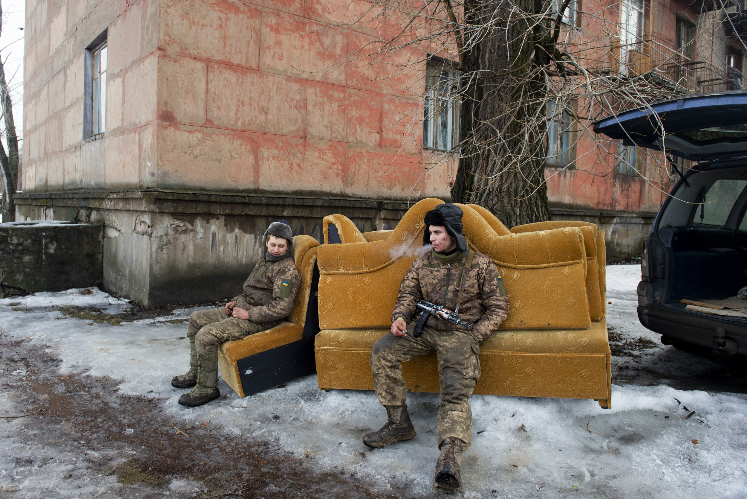  Soldiers of the 54th Mechanized Rifle Brigade take a smoke break while assisting civilians to move during a brief lull in separatist shelling on March 1, 2019 in Zolote-4. The small city of Zolote has been on the frontlines of the Donbas War since i