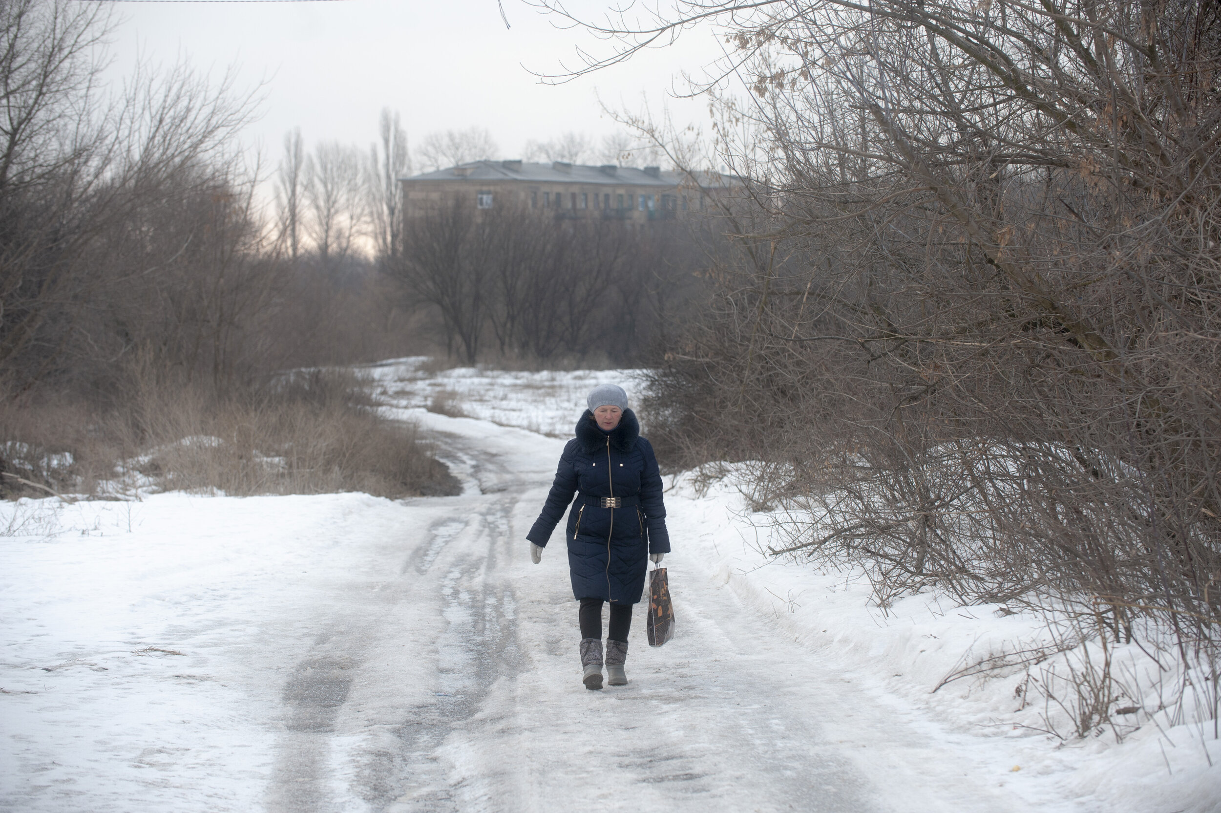 A teacher at the Zolote-4 elementary school braves the long lonely walk from ‘Point Zero’ to town every day to teach the few remaining students at her school. Despite the best efforts of teachers to continue providing education on the frontlines, la