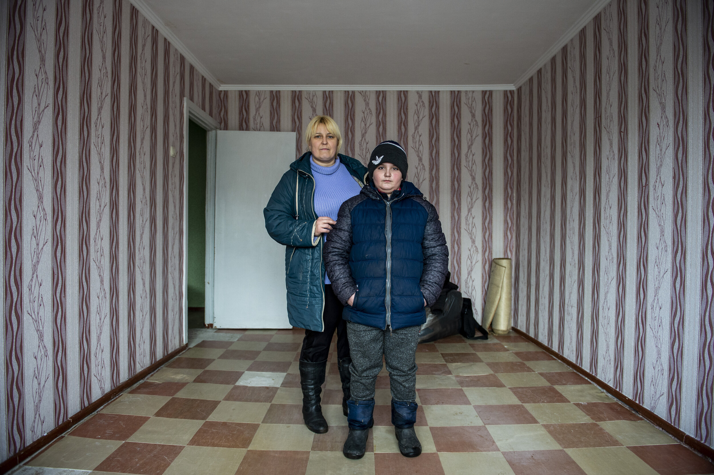  A mother and son pose for a portrait in their new apartment the morning after fleeing their old home after heavy shelling and fighting drove them and others in Zolote-4 away to seek a safer home. There are currently 1.5million internally displaced U