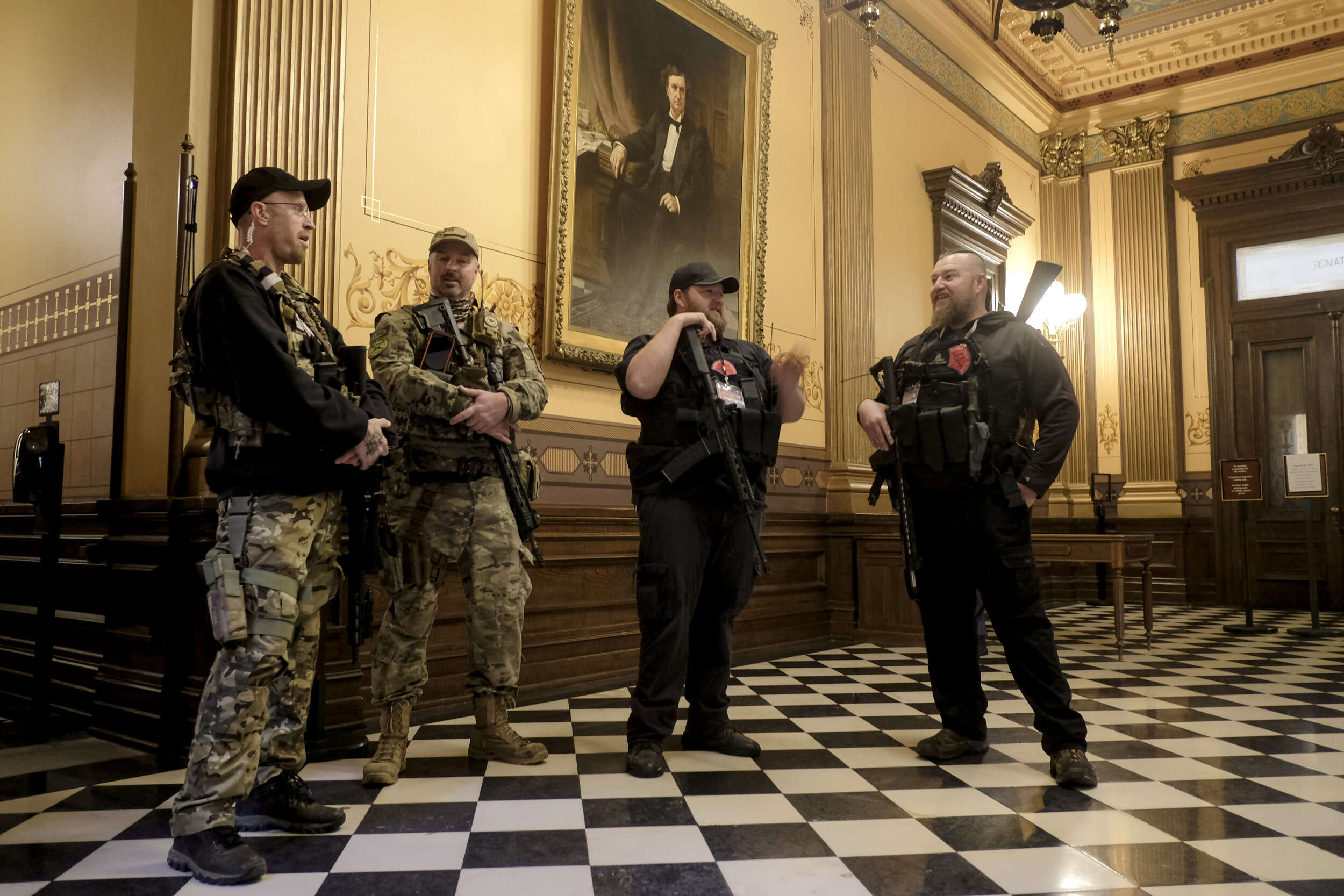 Members of an unnamed Michigan Militia group talk amongst themselves outside the Senate Chamber as they wait for the Senate Session to begin at the Michigan Capitol Building on Thursday, April 30 in Lansing, Michigan. A large number of protesters, s