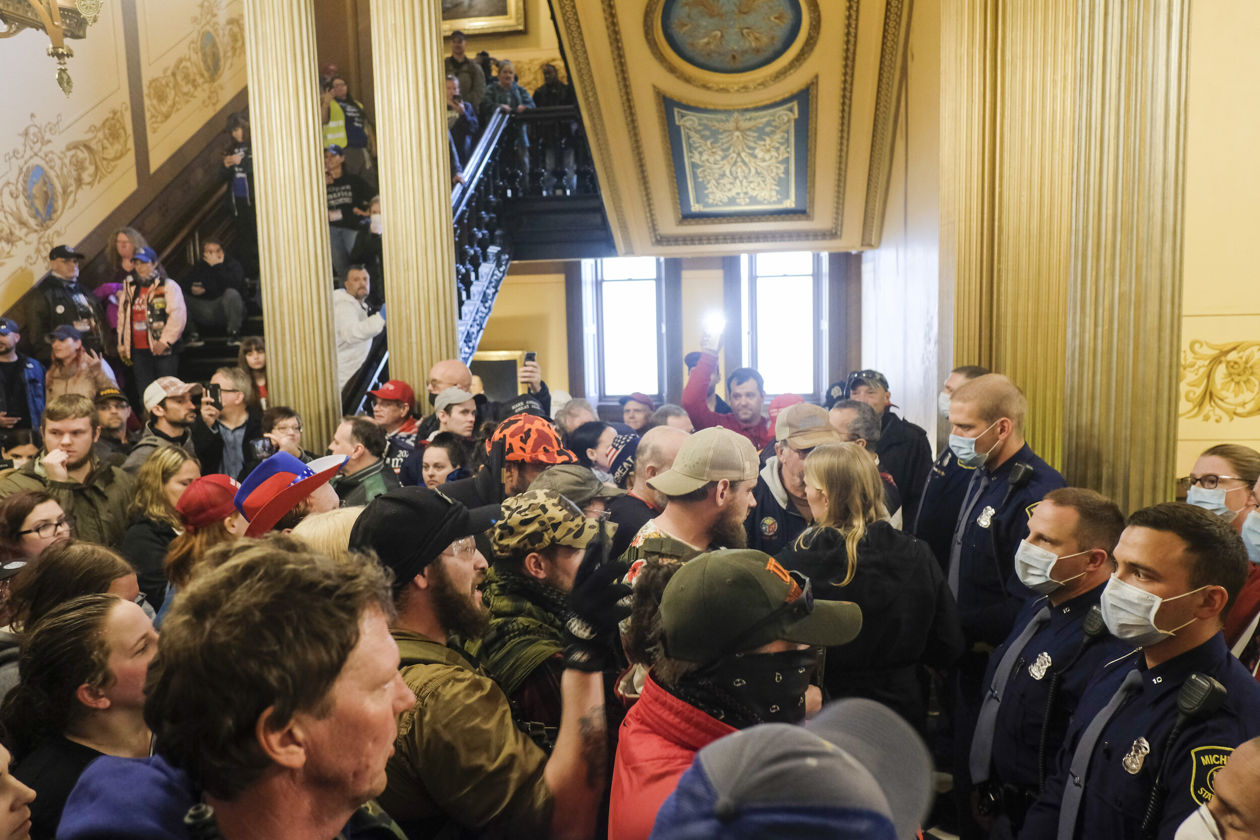  A large crowd of anti-lockdown protesters, some armed and some from various militia groups in Michigan, occupy the area outside the senate chamber in the Michigan Capitol Building in Lansing, Michigan during a protest calling for an end to the state