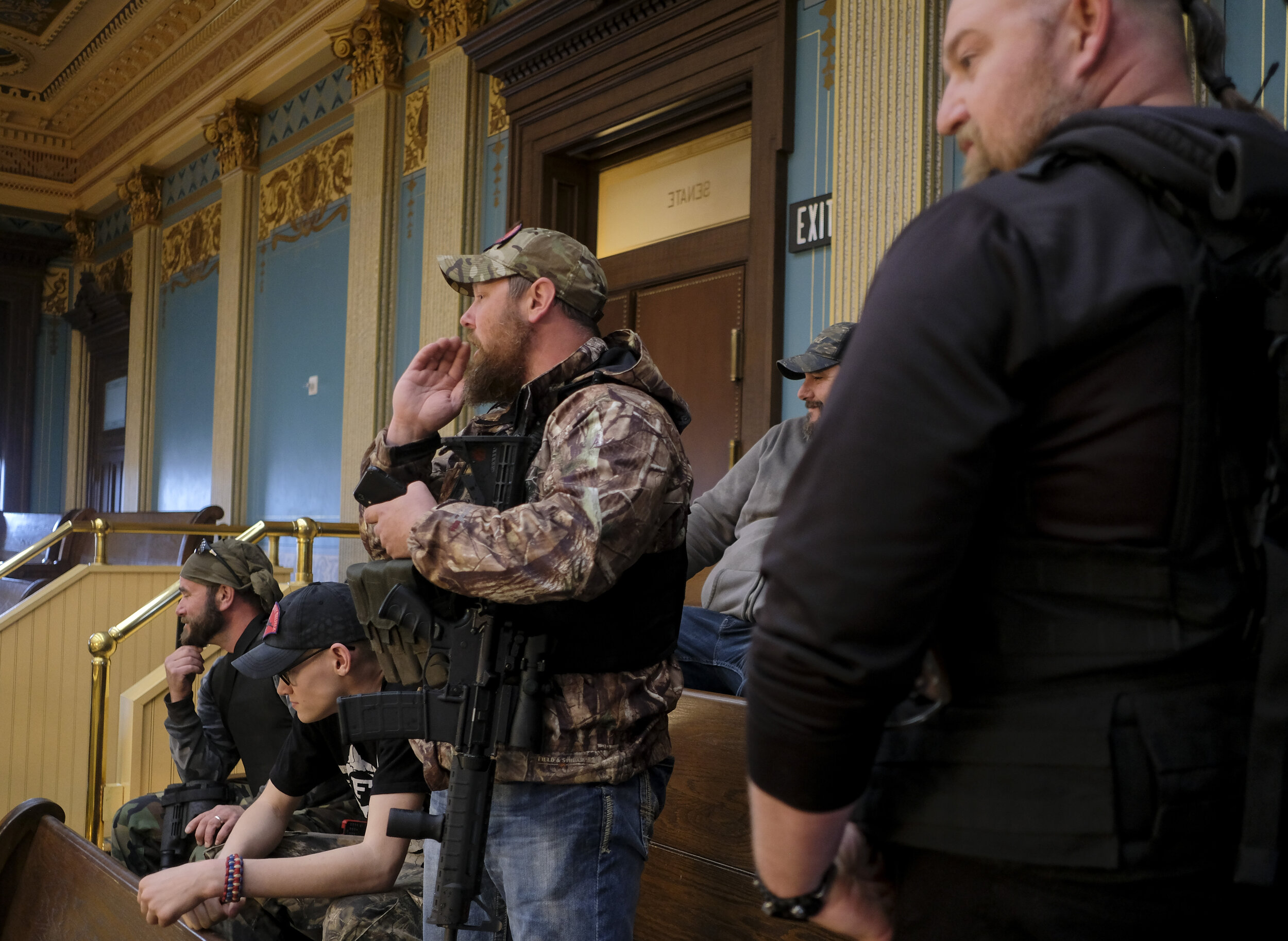  A milita member shouts “You just remember you work for us! Enjoy your paycheck while you still get it!” at Michigan senate members during a senate session at the Capitol Building in Lansing, Michigan  on Thursday, April 30. Protesters, some armed, h