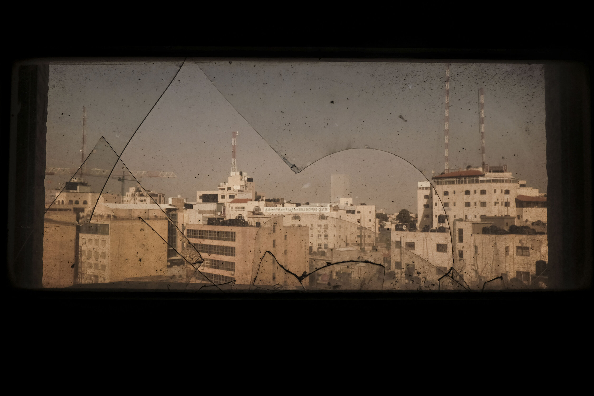  A view of Ramallah from a broken window in a high rise skyscraper near Al-Manara Square in the Occupied West Bank. While once a land of shepherds and olive trees, Ramallah has been transitioning away from agriculture and is becoming increasingly urb