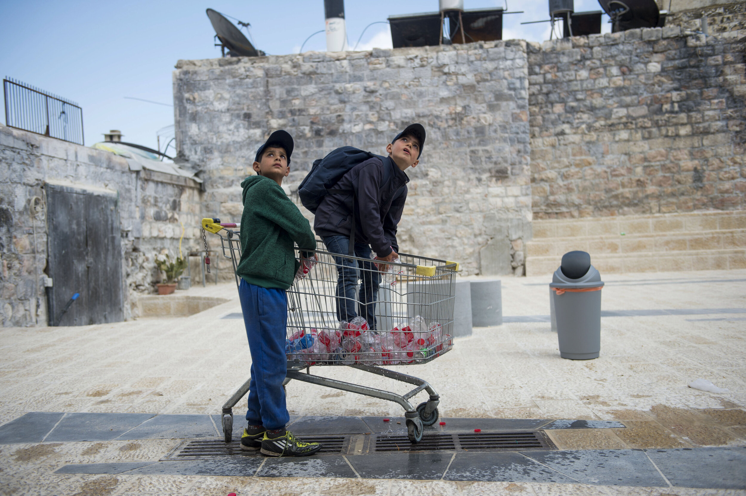 Palestinian youths look up at Israeli youths as they throw water bottles and shout insults at them shortly before the Flag March through the Old City in Jerusalem. The March occurs annually in Jerusalem and is a celebration commemorating the victory