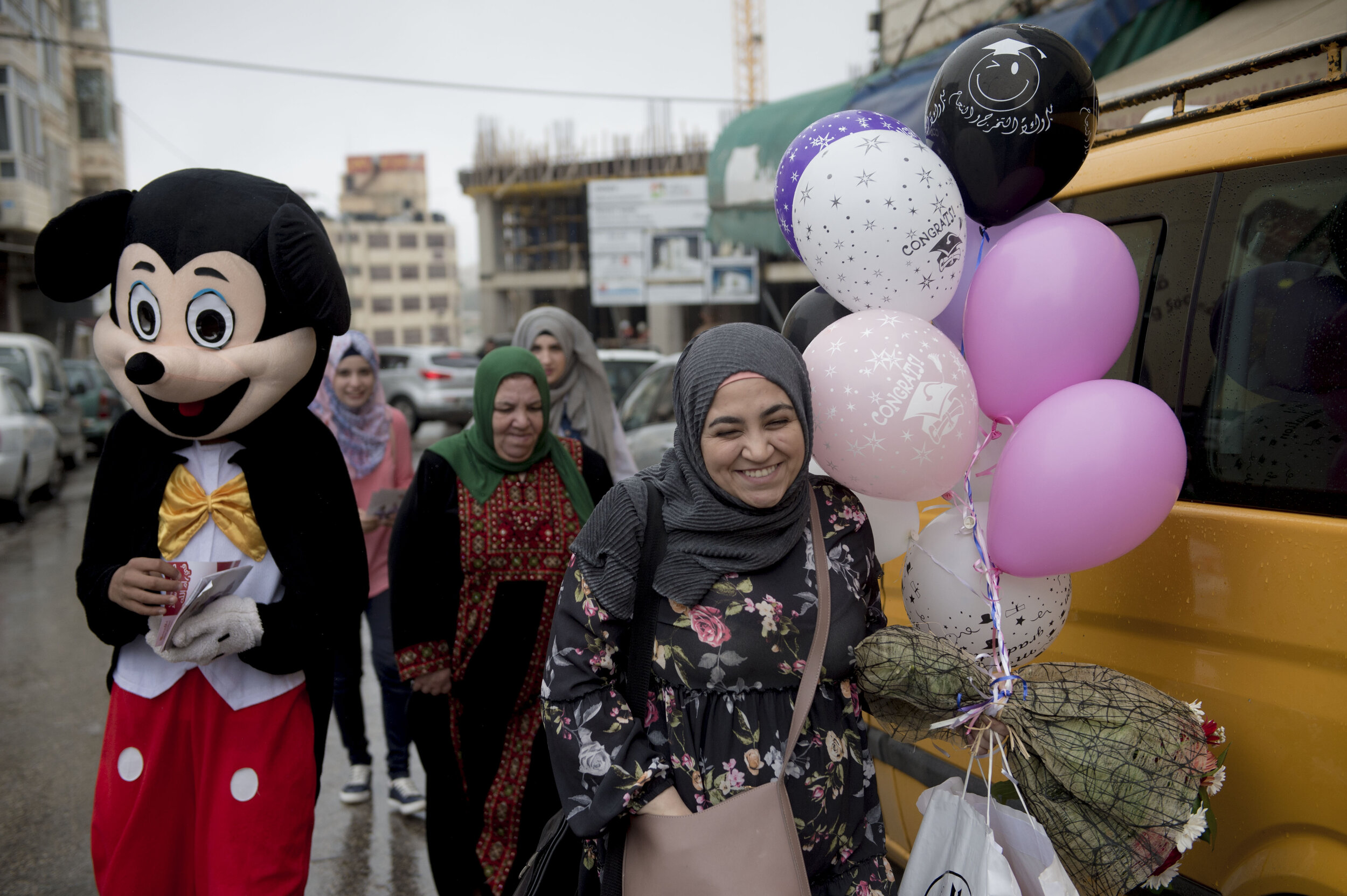 A Palestinian woman laughs as she interacts with a mascot at the opening of a new restaurant in downtown Ramallah in the Occupied West Bank. More and more Palestinians are venturing into running their own businesses in restaurants and commercial ret