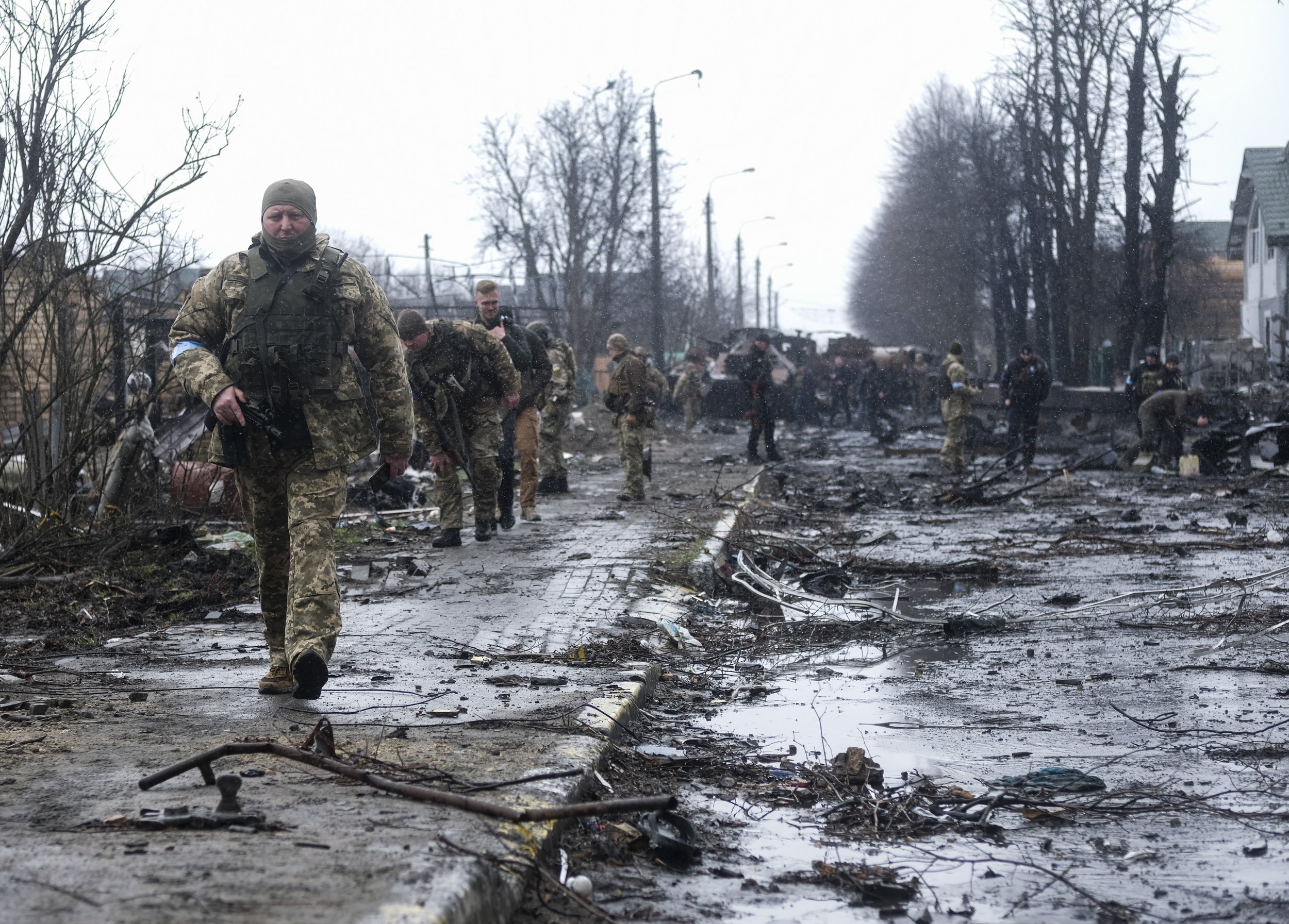 Ukrainian soldiers walk down a street in Bucha, Ukraine that has been annihilated and is crowded with dead Russian soldiers and destroyed armored vehicles on April 3, 2022. Bucha, a small village on the outskirts of Kyiv saw some of the fiercest fig