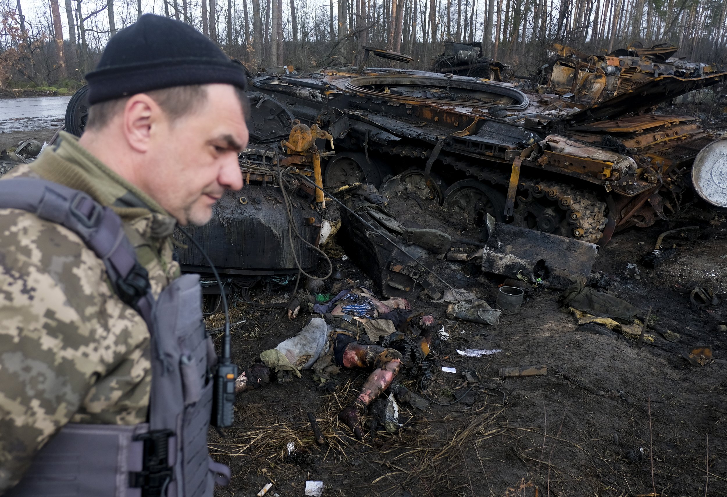  A Ukrainian soldier walks past the corpse of a dead Russian soldier at the scene of an ambush on a Russian armored column on the outskirts of Bucha on April 3, 2022. Ambushes like this by Ukrainian volunteer units and soldiers armed with Javelin mis