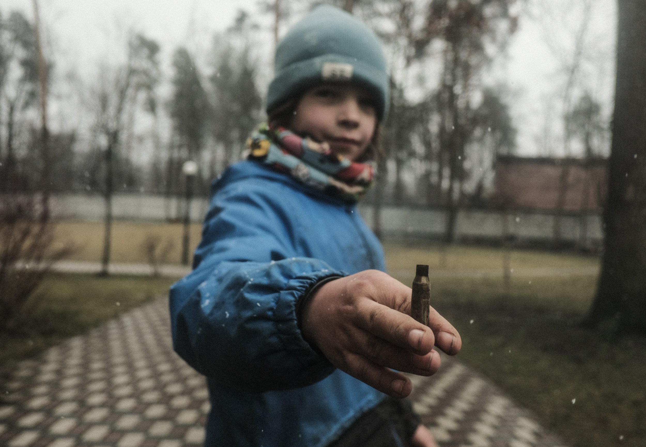  A child holds up a shell casing for a picture in Bucha, Ukraine on April 3, 2022. The child and his family hid in the basement of their apartment building during the heavy fighting and occupation of the town. Following the liberation by Ukrainian tr