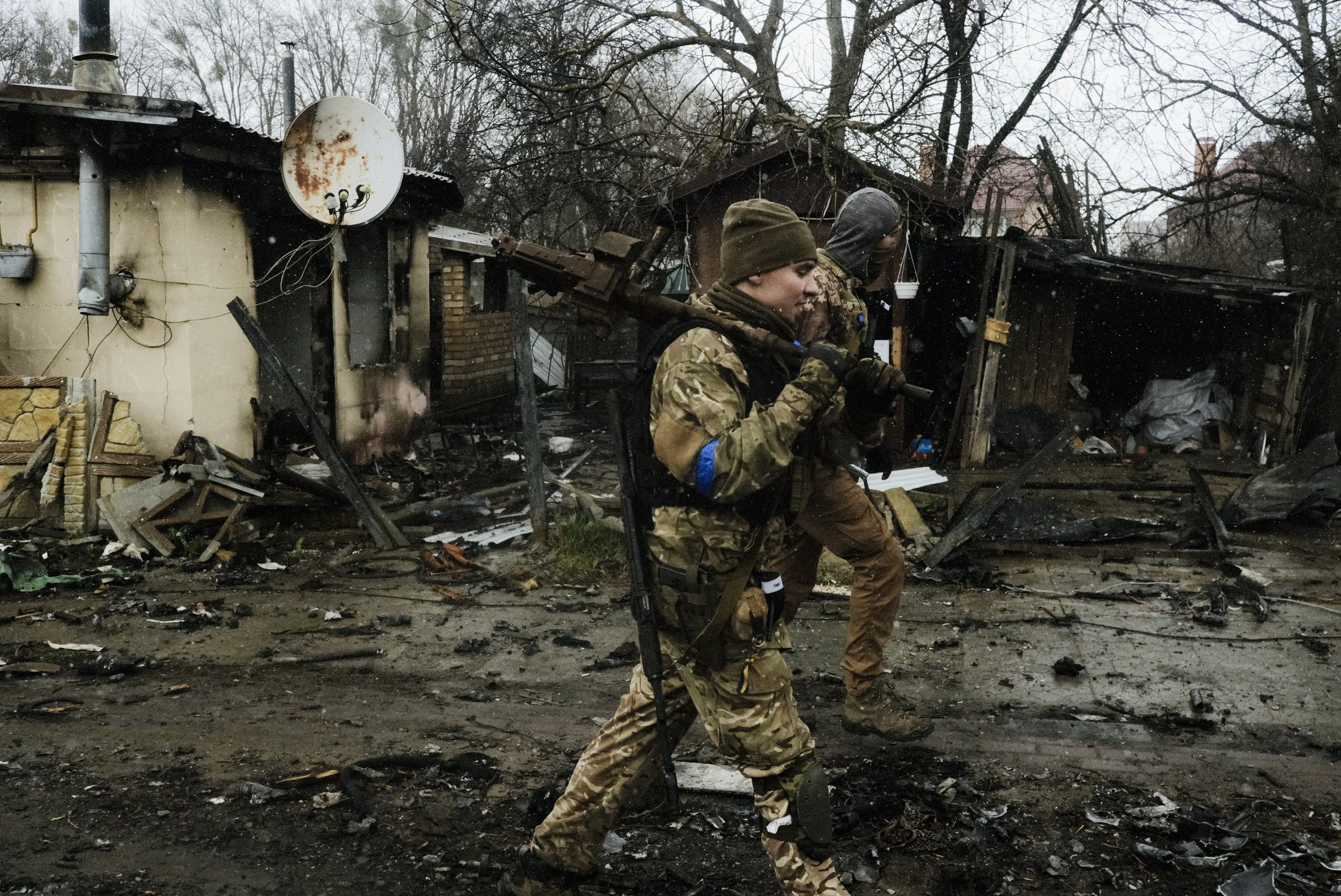  Ukrainian soldiers carry a machine gun and other equipment stripped from destroyed tanks in Bucha, Ukraine on April 3, 2022. Fierce fighting in the suburbs of Kyiv eventually forced the poorly trained and unprepared Russian forces to withdraw to the
