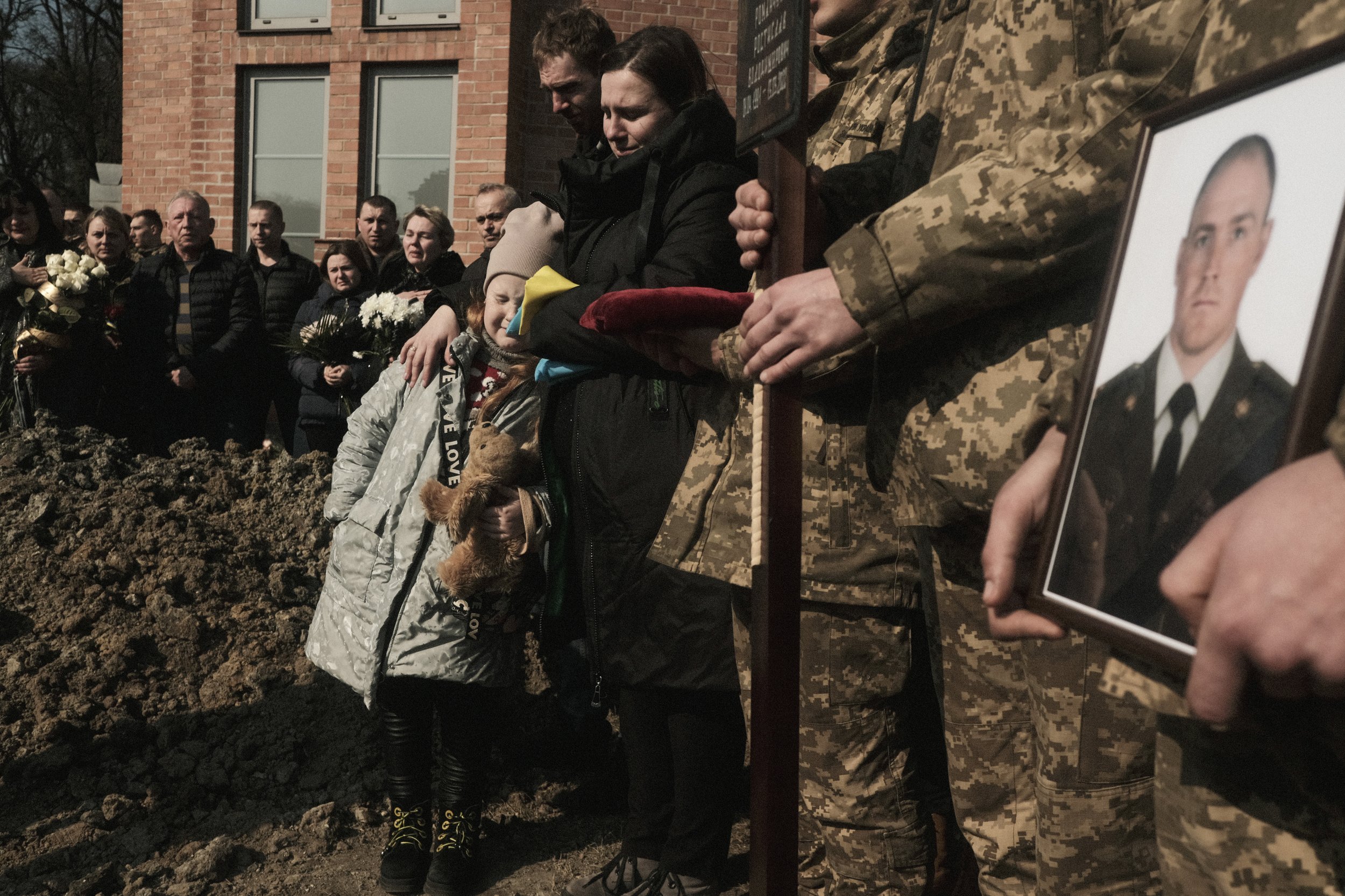  The daughter of Rostyslav Romanchuk, eight-year-old Viktoria, cries as her father's casket is lowered into his grave at the Lychakivske Cemetery in Lviv, Ukraine. Romanchuk was one of 35 killed in an airstrike on a military base near the Polish bord