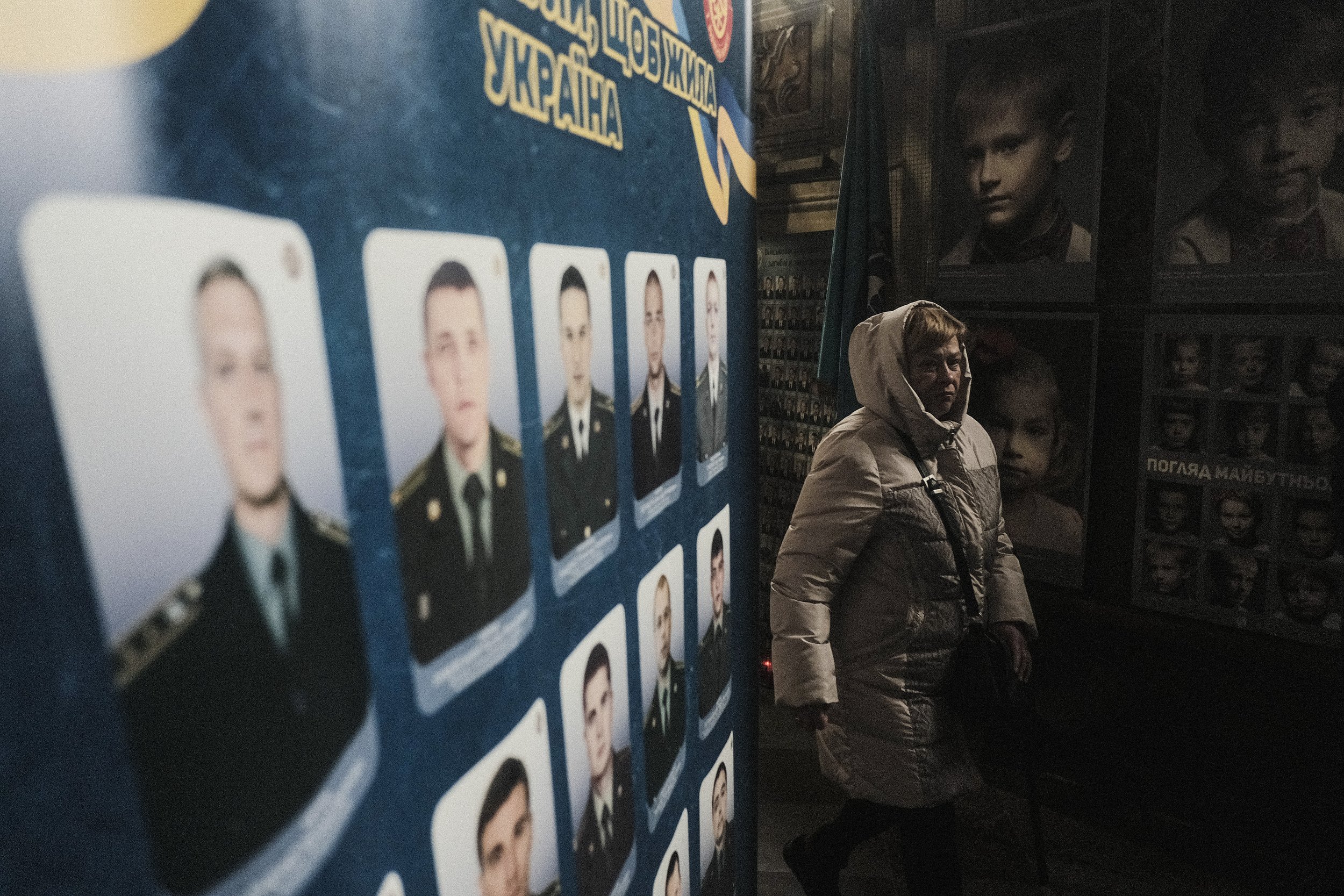  A woman walks past the portraits of soldiers and civilians killed by Russian troops and Russian-backed separatists in the Church of the Most Holy Apostles Peter and Paul during mass on March 10th, 2022. The church serves both as the site of frequent