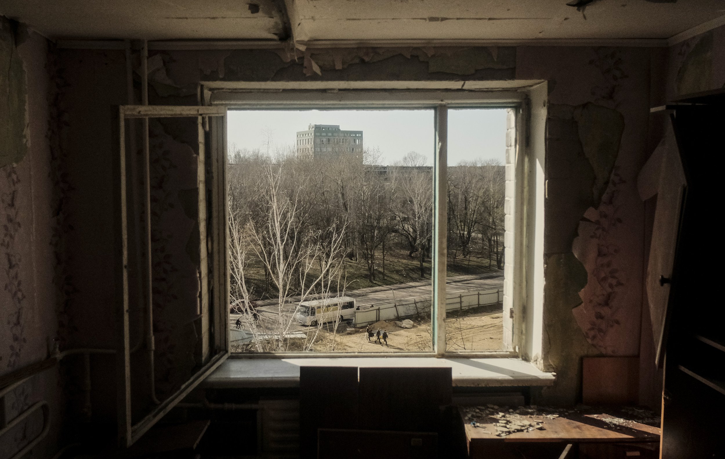  Soldiers are seen from a destroyed apartment building window exiting a bus to man positions in Chernihiv, Ukraine on April 15, 2022. Chernihiv saw intense fighting that destroyed much of the city and its infrastructure.  