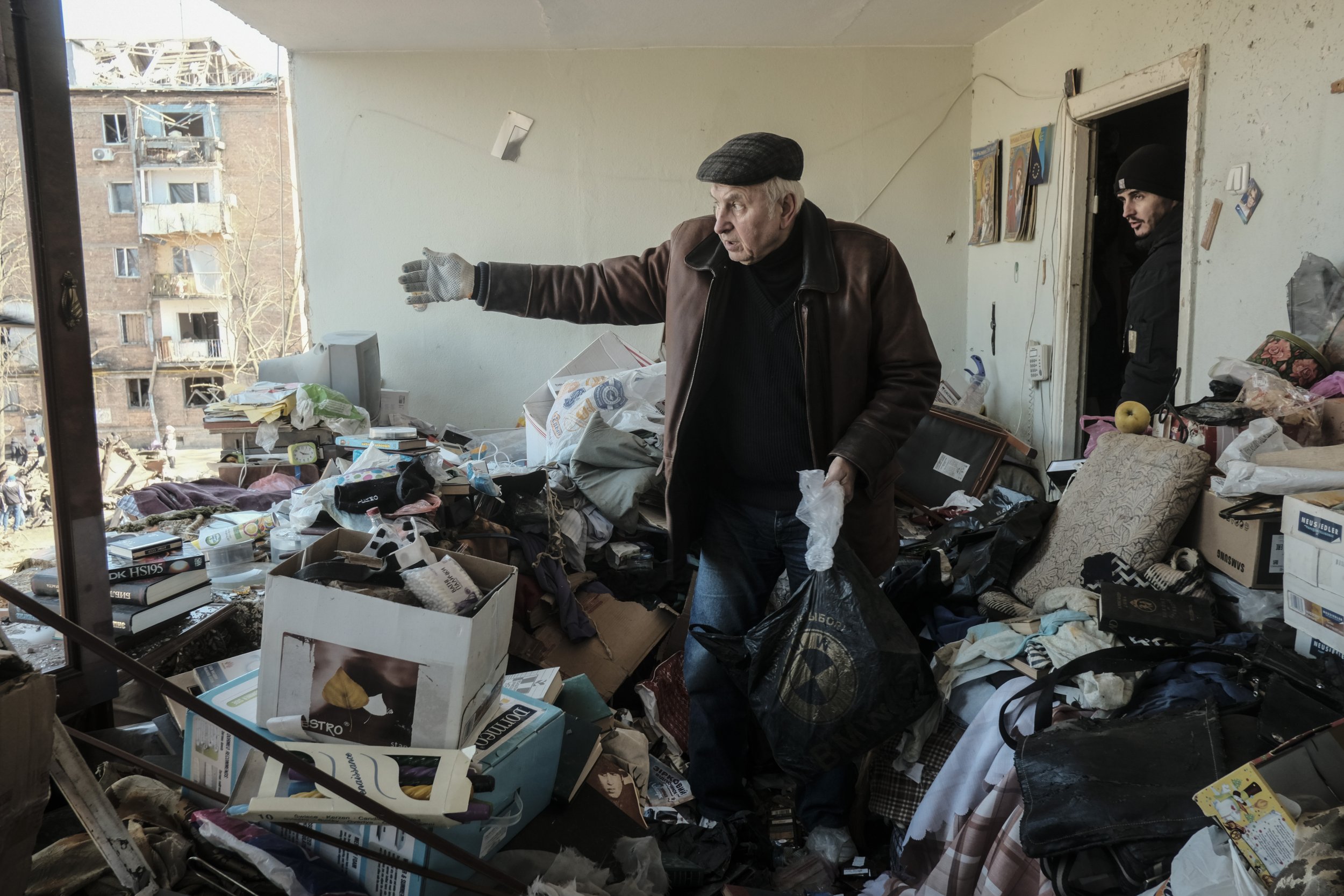  A Ukrainian civilians goes through his belongings after a missile struck the courtyard of his apartment building and destroyed multiple structures on March 15, 2022. As Russia attempted to encircle Kyiv they continually launched drone and missile st