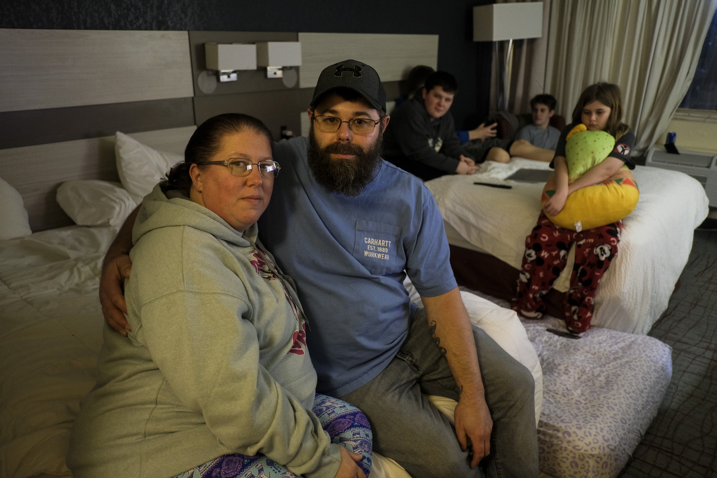  Chris Whittenberger and his partner Nicole Bentel pose for a portrait in their hotel room in Beaver Falls, Pennsylvania on Saturday, February 18, 2023. The couple and their children have been staying in hotels since evacuating from their home in Eas