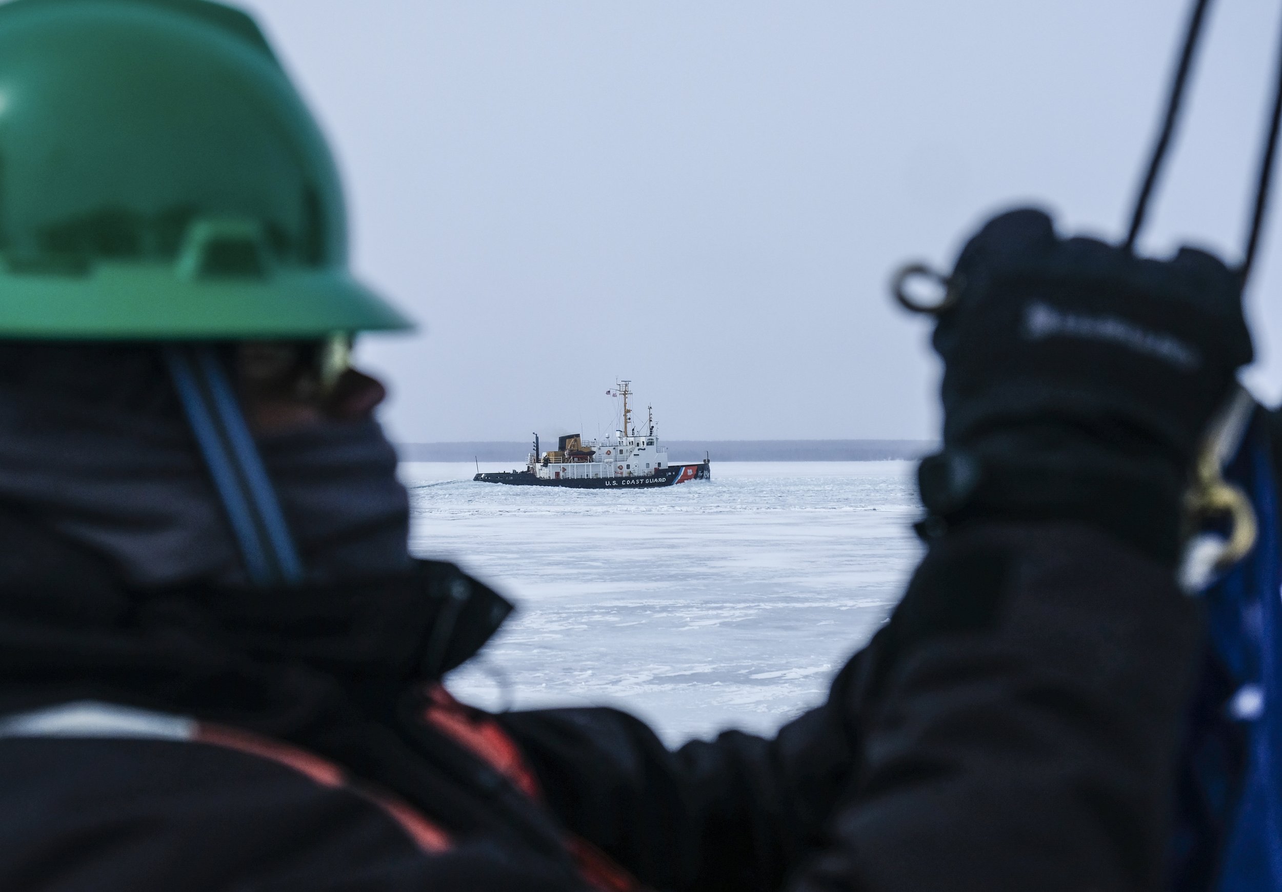  Seaman Dayon Caron Marcoos ties on the Union Jack to the back of the US Coast Guard Cutter 'Katmai Bay' after mooring at Lime Island following ice-breaking operations on Tuesday, March 14, 2023, near Lake Huron as the USCGC Morro Bay, another Ice Br