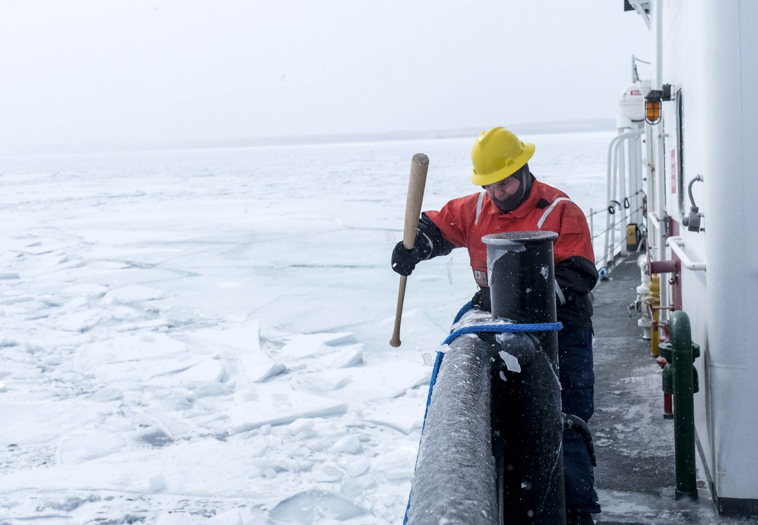 Boatswain's Mate Bruce Carter breaks ice on the forward deck of US Coast Guard Cutter  'Katmai Bay' during an operation to clear a Frozen section of the St. Mary's river on Tuesday, March 14, 2023 near Lake Huron. 