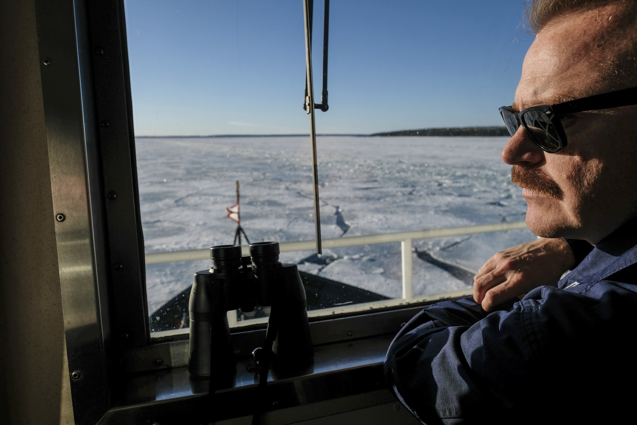  Captain Mike Overstreet of the US Coast Guard Cutter Katmai Bay scans the horizon of the St. Mary's River for ice sheets from the bridge of his vessel, USCGC Katmai Bay on Tuesday, March 14, 2023. The Katmai Bay is one of the ships in the US Coast G
