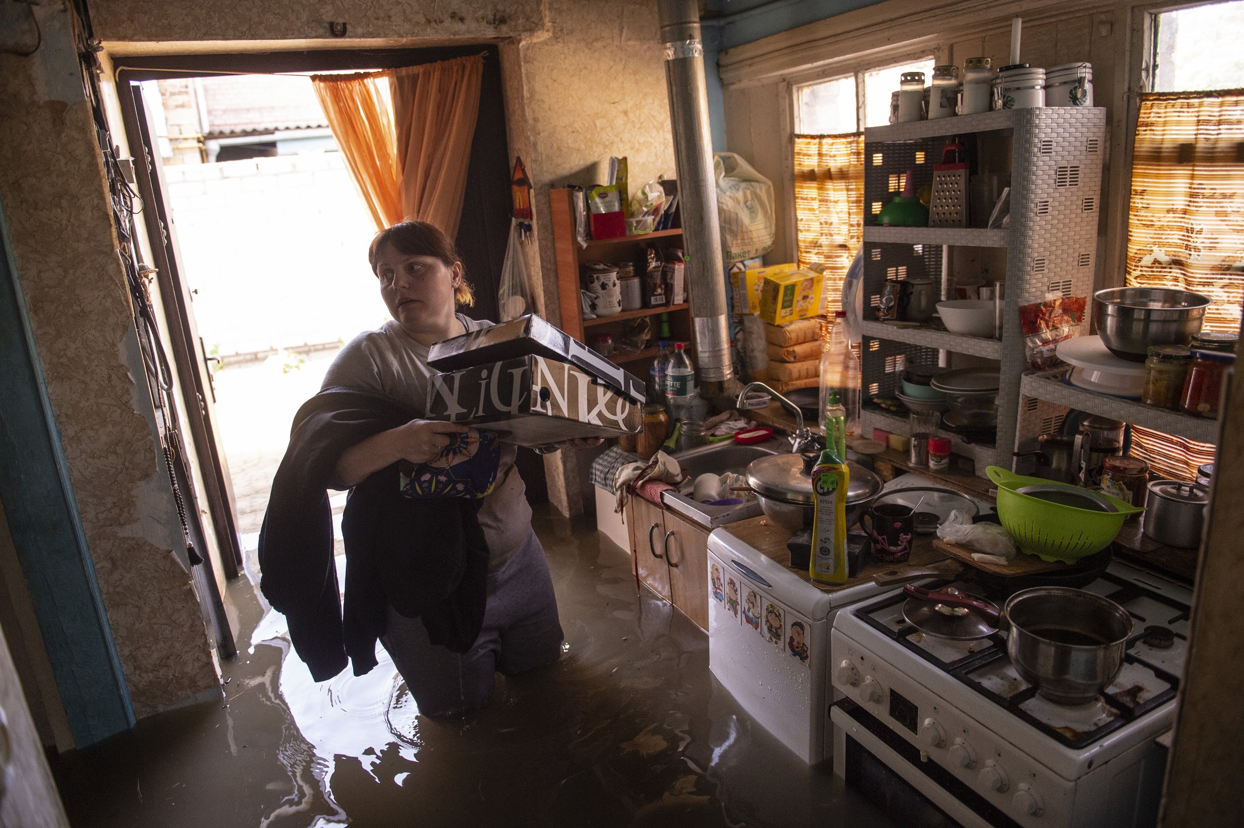  A woman grabs important belongings as she is forced to abandoned her flooding home in Kherson, Ukraine on June 7, 2023. The previous day Russian forces destroyed the Kharkovka Dam near Zaporizhia, which unleashed flood waters down the Dnipro river, 