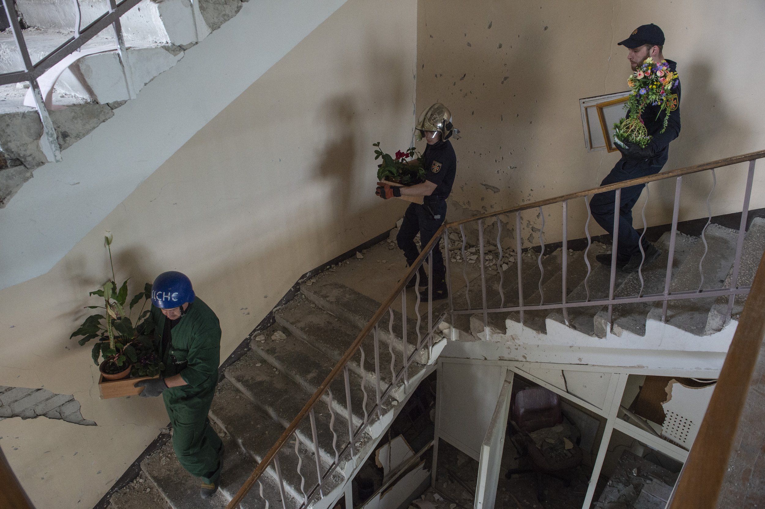  Emergency workers carry plants out of the Dnipro Regional Emergency Services Office after a Russian Missile struck the building and destroyed numerous emergency vehicles and equipment on May 24, 2023.   