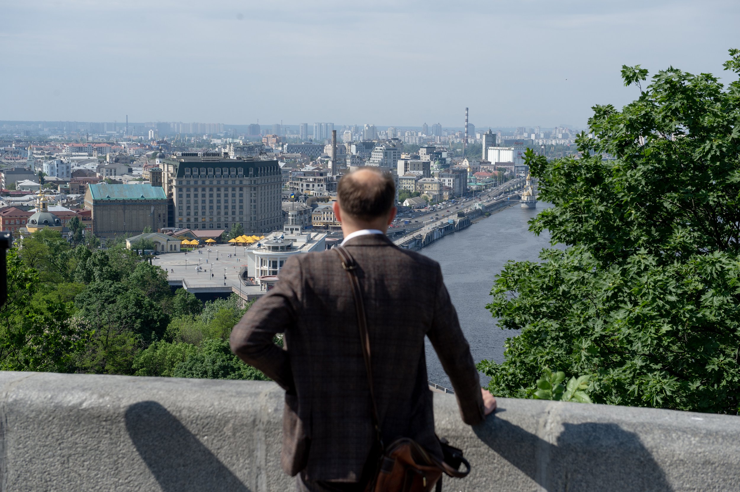  A man overlooks Kyiv along the Dnipro River from a park in Kyiv on May 20, 2023. One year earlier Kyiv was the target of the invading Russian troops.  