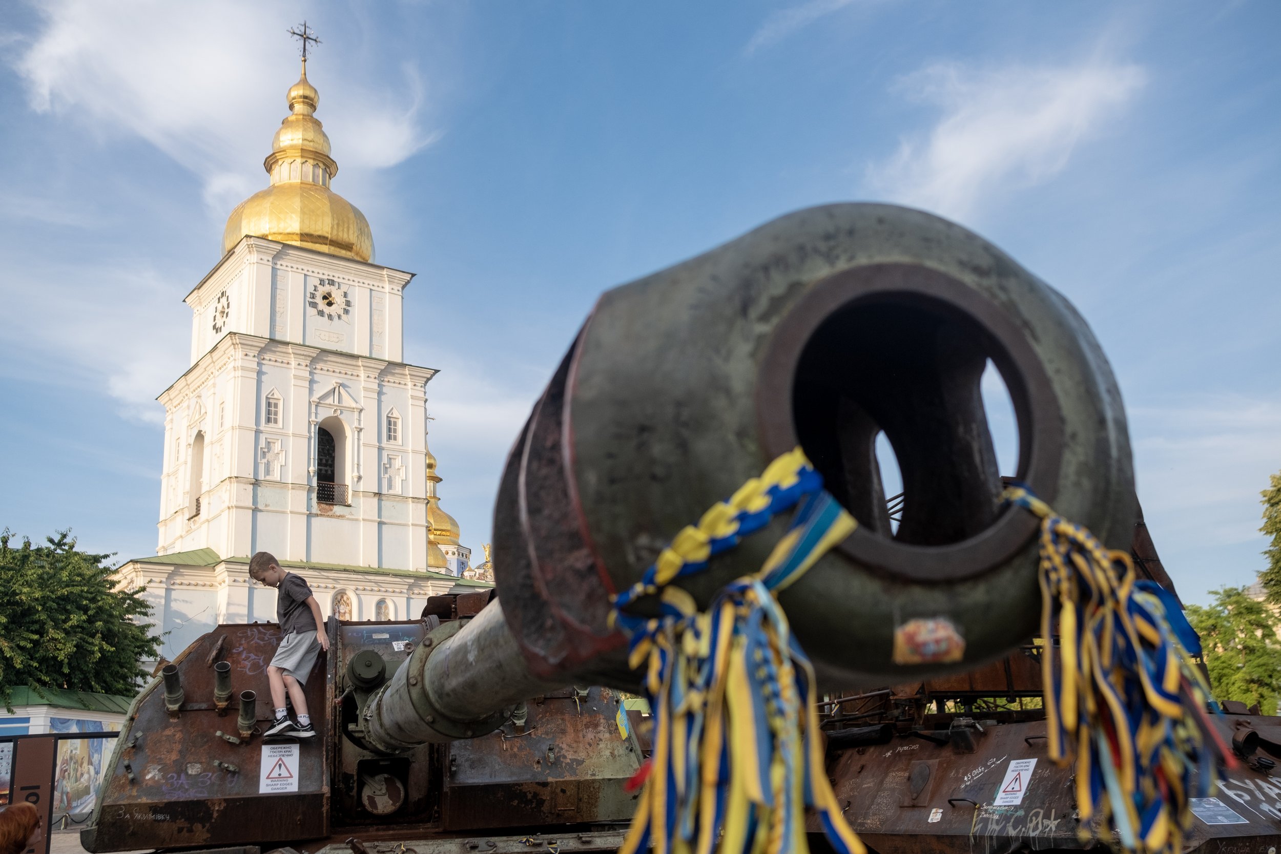  A young boy climbs atop the remains of a destroyed Russian tank on display in Mykhailivska Square in Kyiv, Ukraine on June 18, 2023. Captured and destroyed pieces of Russian military equipment are put on display in Kyiv for civilians to come and exa