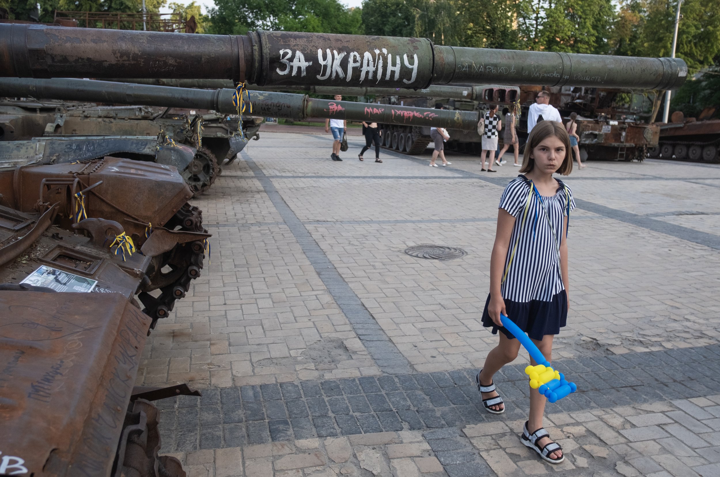  A girl walks past captured and destroyed Russian tanks in Mykhailivska Square in an area that has become an open-air museum for war machines that Ukrainian civilians can visit.   