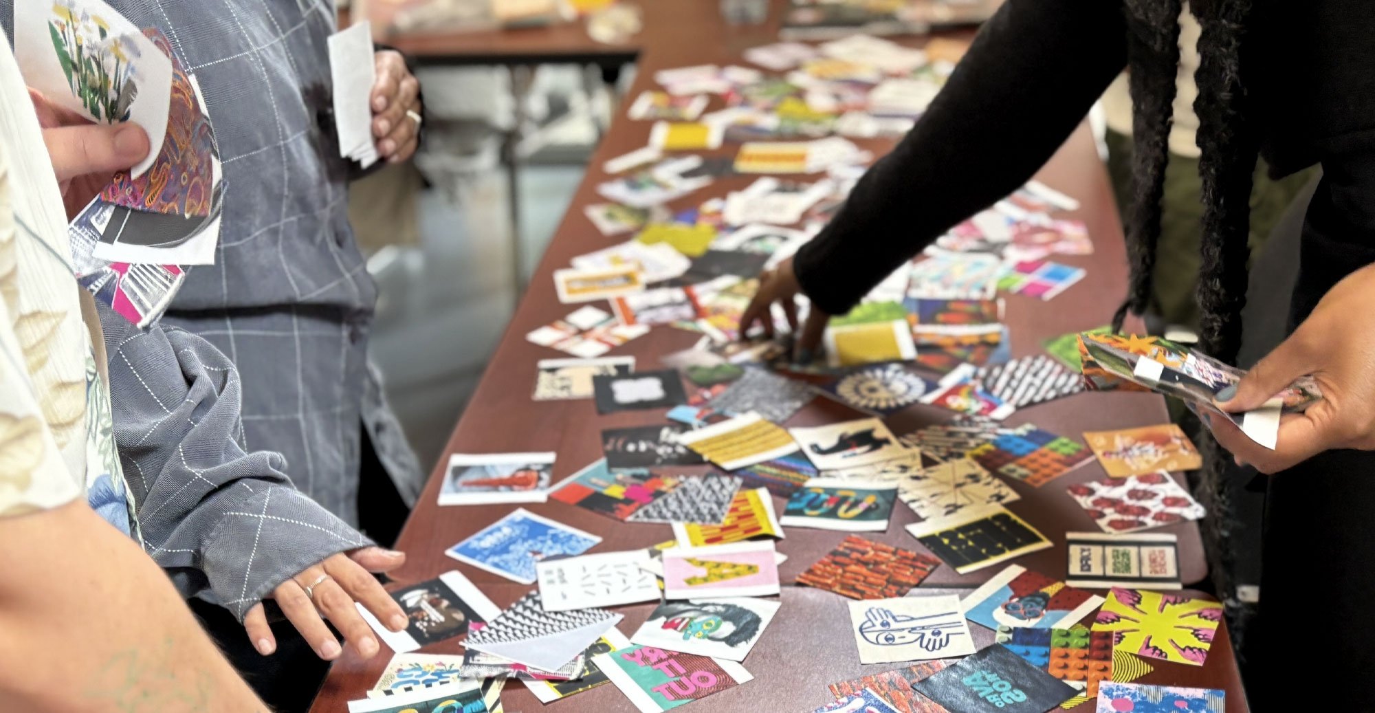 Photo of peoples hands shifting through visual precedents and inspiration during a co-creative community session