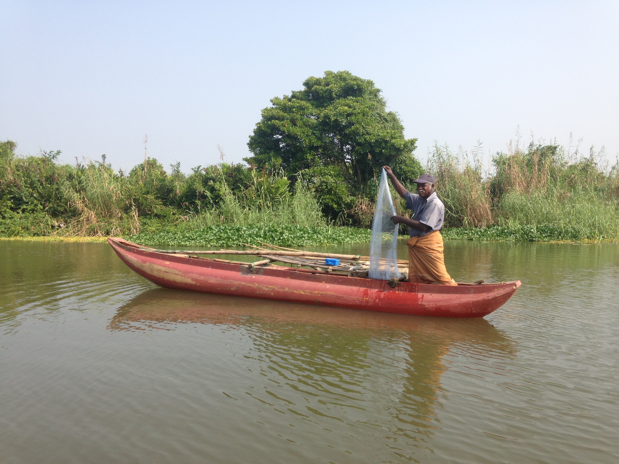  A fisherman sorting through his nets in a lagoon. 