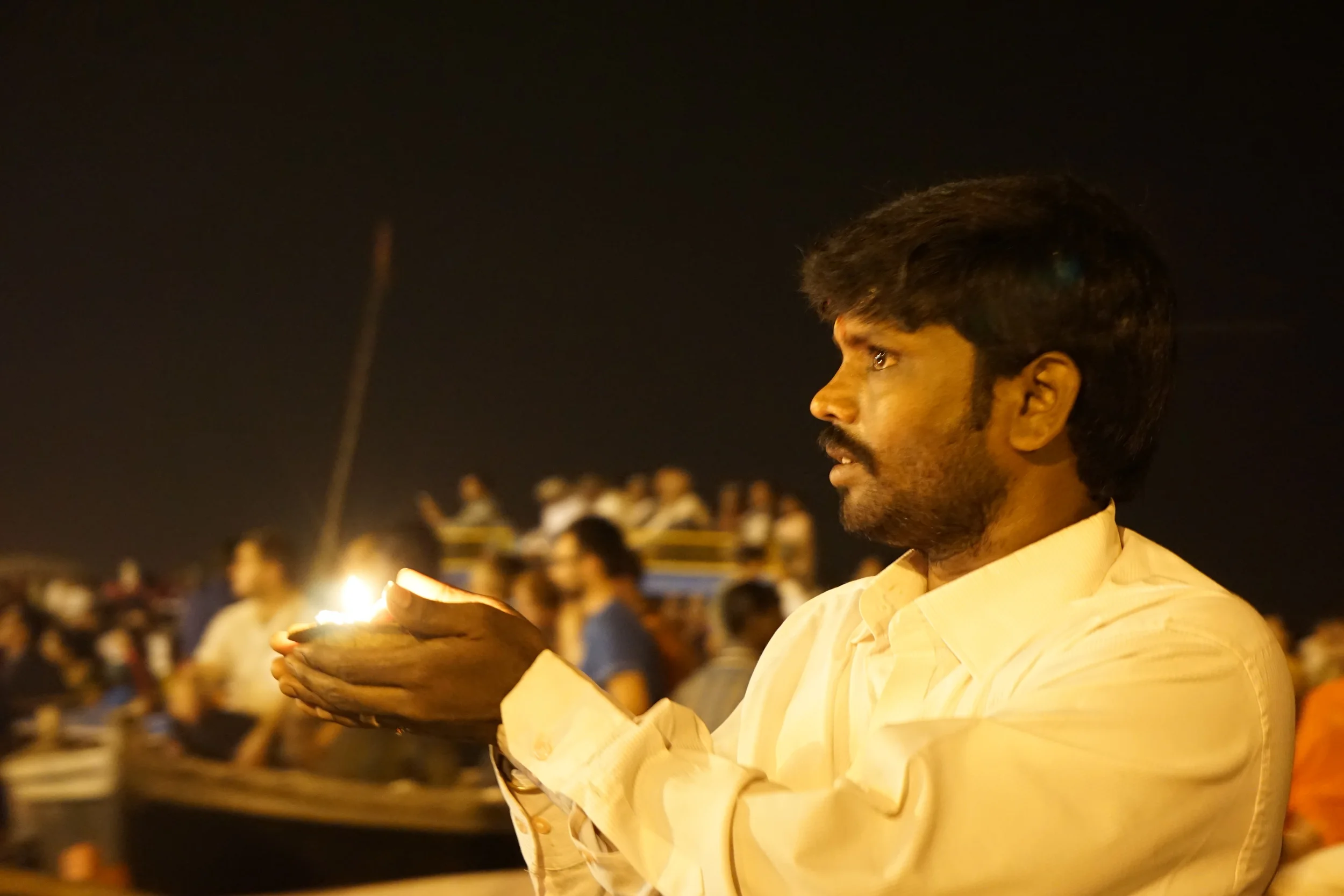 My fellow boat rider with a candle inside flowers that are sent to float down the river.
