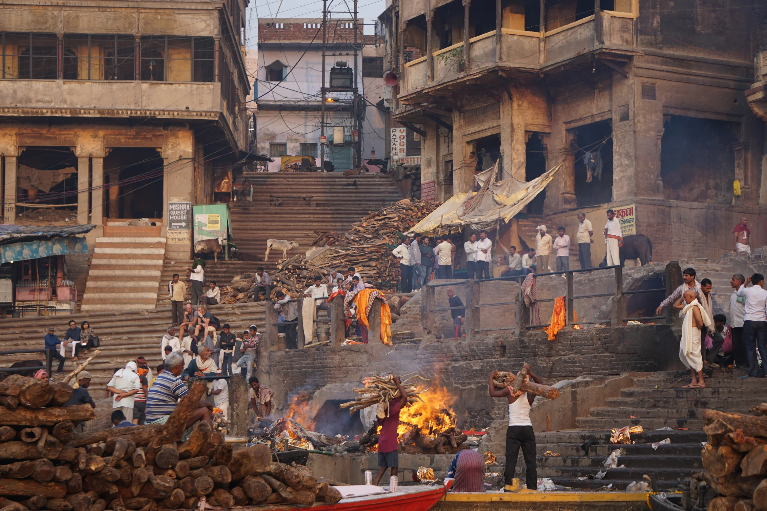 Men carrying logs for more pyres at a burning ghat.