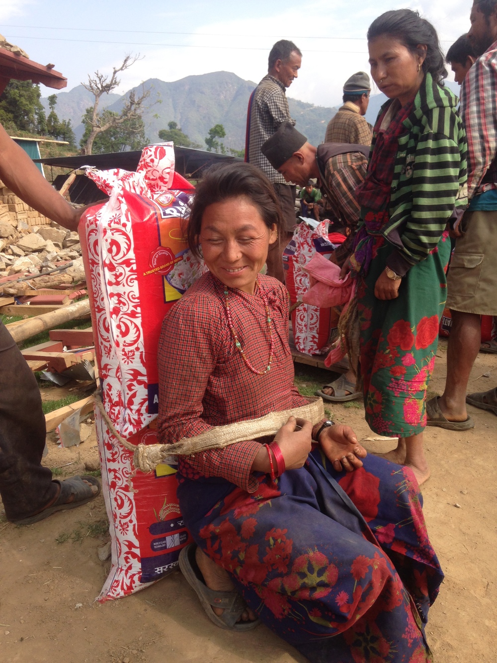  Another woman preparing to shoulder a heavy bag of rice. 