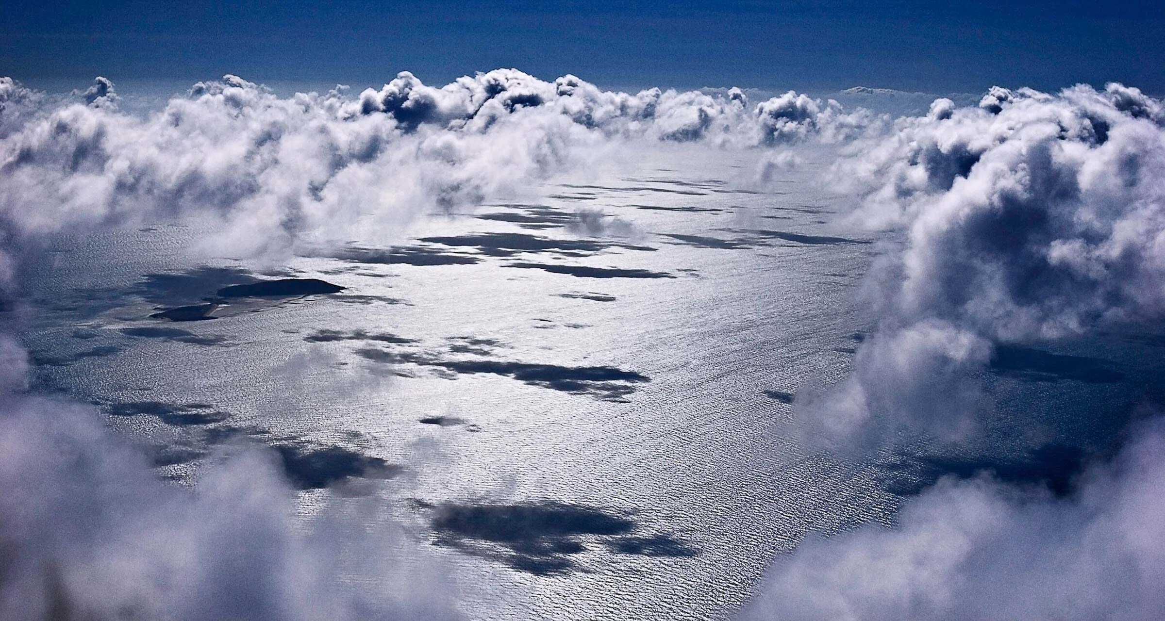  Sea view, clouds and shadows from cockpit of light aircraft. 